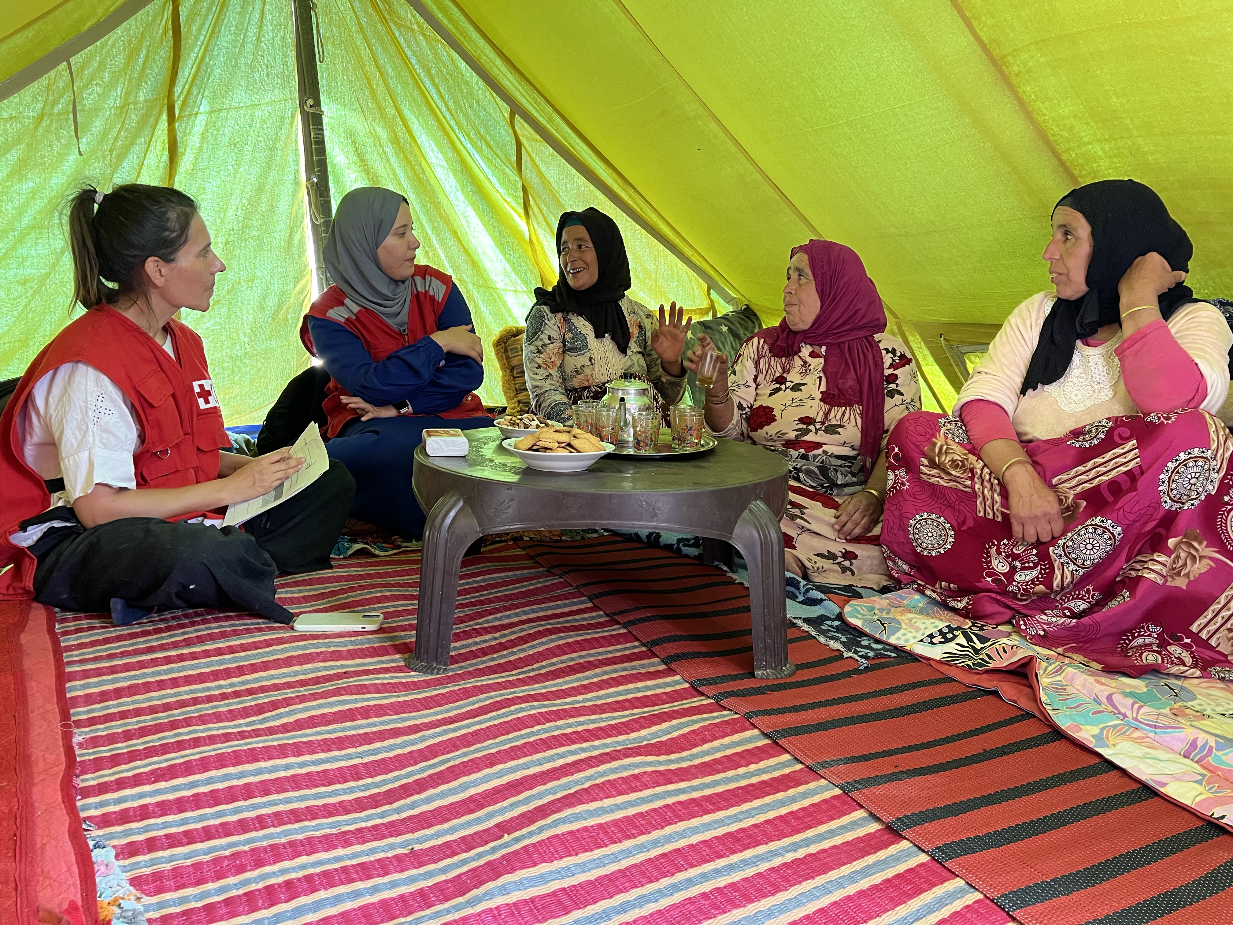 IFRC Community Engagement and Accountability coordinator Monica Posada and Moroccan Red Crescent volunteer Maryam Chtitihi talk with women from the village of Tagadirt to ensure they have a central voice as their community charts its path toward recovery. 
