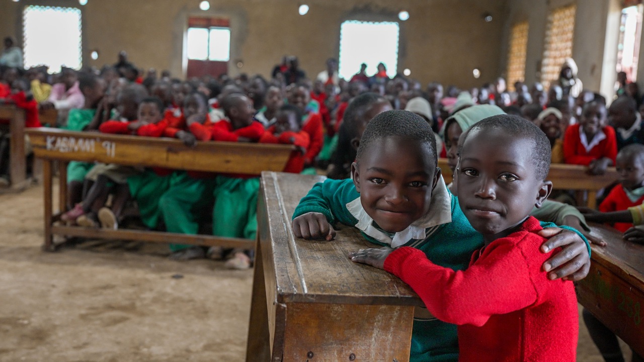 Two young students at Mwisi Primary School in south-west Uganda hug each other during an educational play put on by the School Health Club.