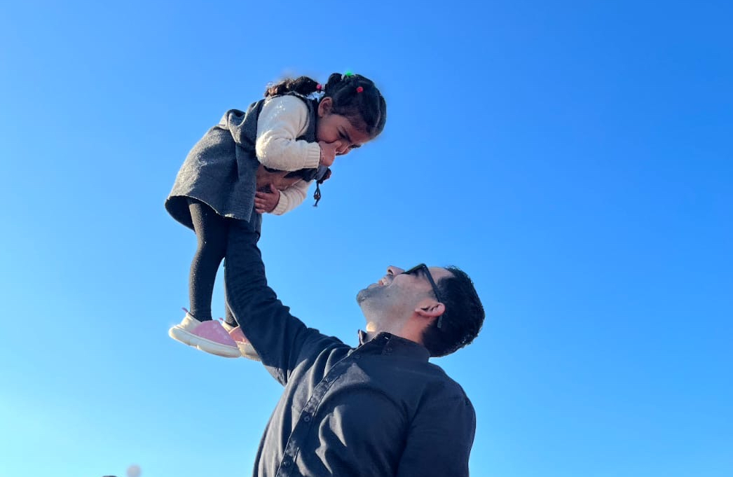 عمرو مع ابنته ماريا خلال فعالية نُظمت للأطفال في المخيم الذي يقيمون فيه في رفح. 
