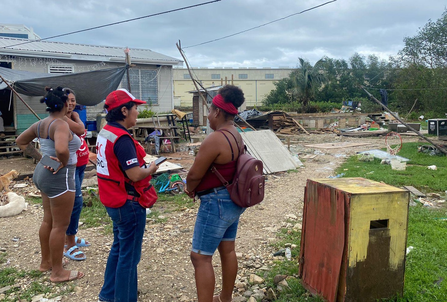 Diana Oviedo, IFRC operations coordinator in Central America, talks to people impacted by Tropical Storm Lisa in Belize. She is one of the many women to manage major operations after taking part in a women's leadership initiative that started in 2020.