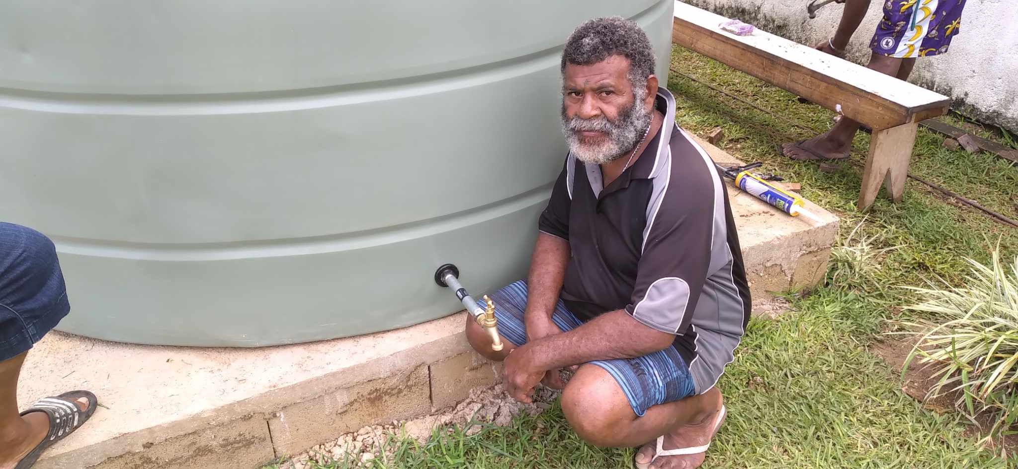 Eric Tangarasi, 51, chief of Mango station, sits on the water-tank foundation built with the help of young Vanuatu Red Cross volunteers.
