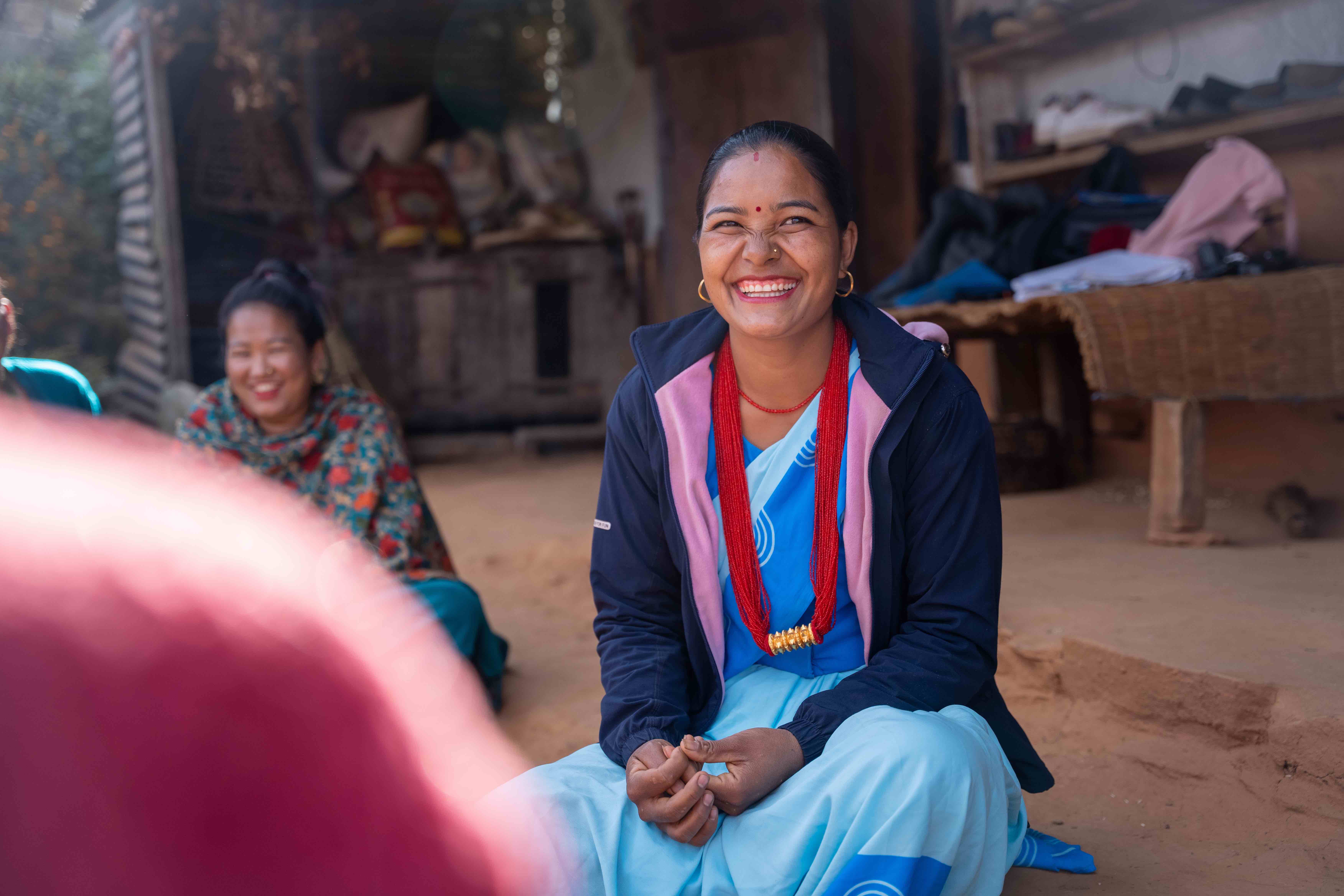 There are many smiles and laughs as Indira, pictured here, leads the team of women community health volunteers through a discussion about health and hygiene.