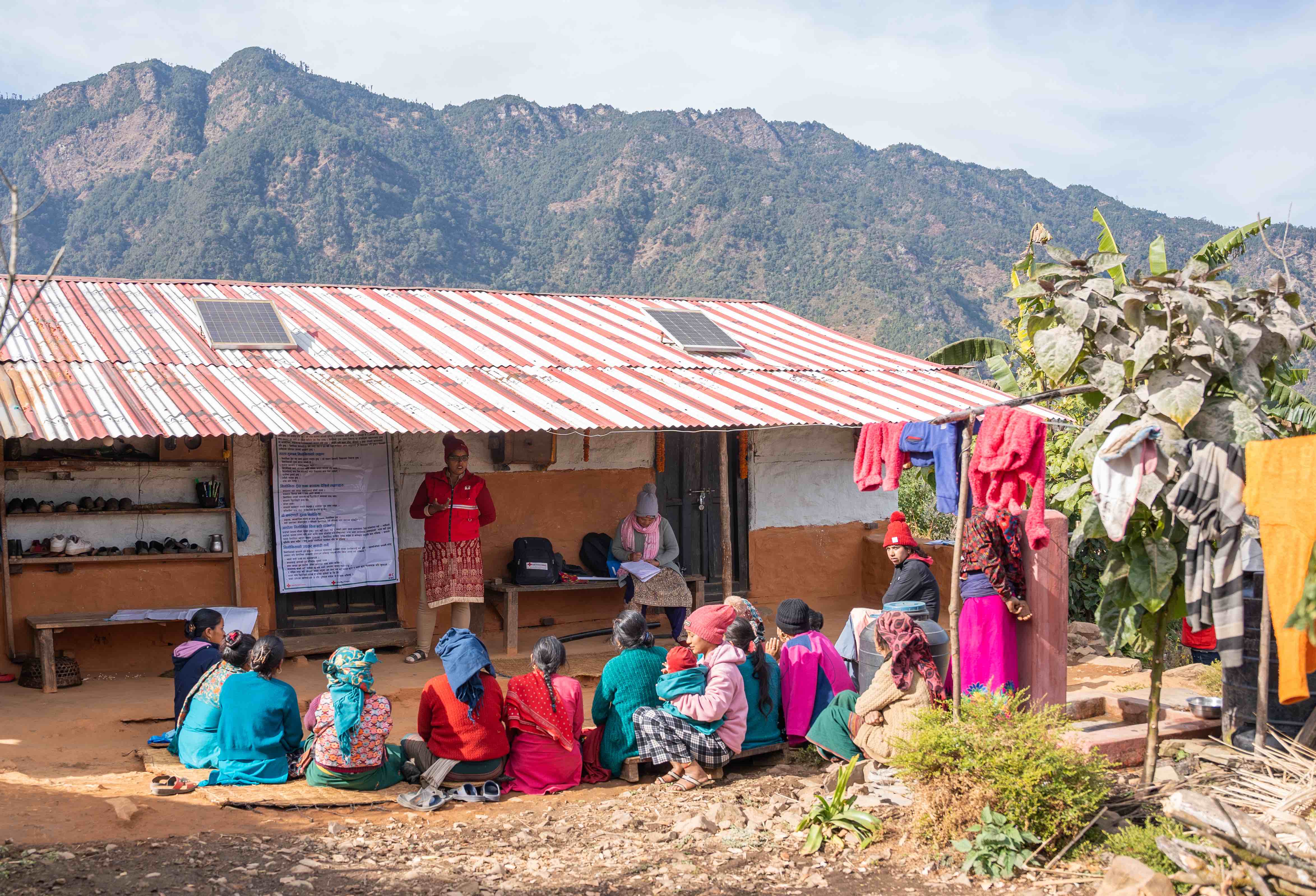Nepal Red Cross volunteer Muna demonstrates proper handwashing steps to school children gathered at a local school.