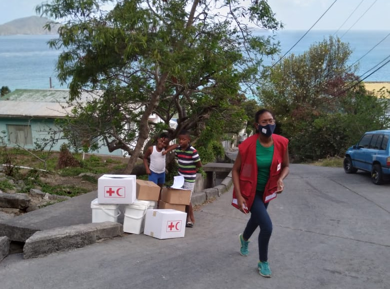 Rhea Pierre, disaster preparedness and climate-crisis coordinator for IFRC in the English and Dutch speaking Caribbean, drops off basic living supplies following the eruption of the La Soufrière volcano in St. Vincent and the Grenadines. 