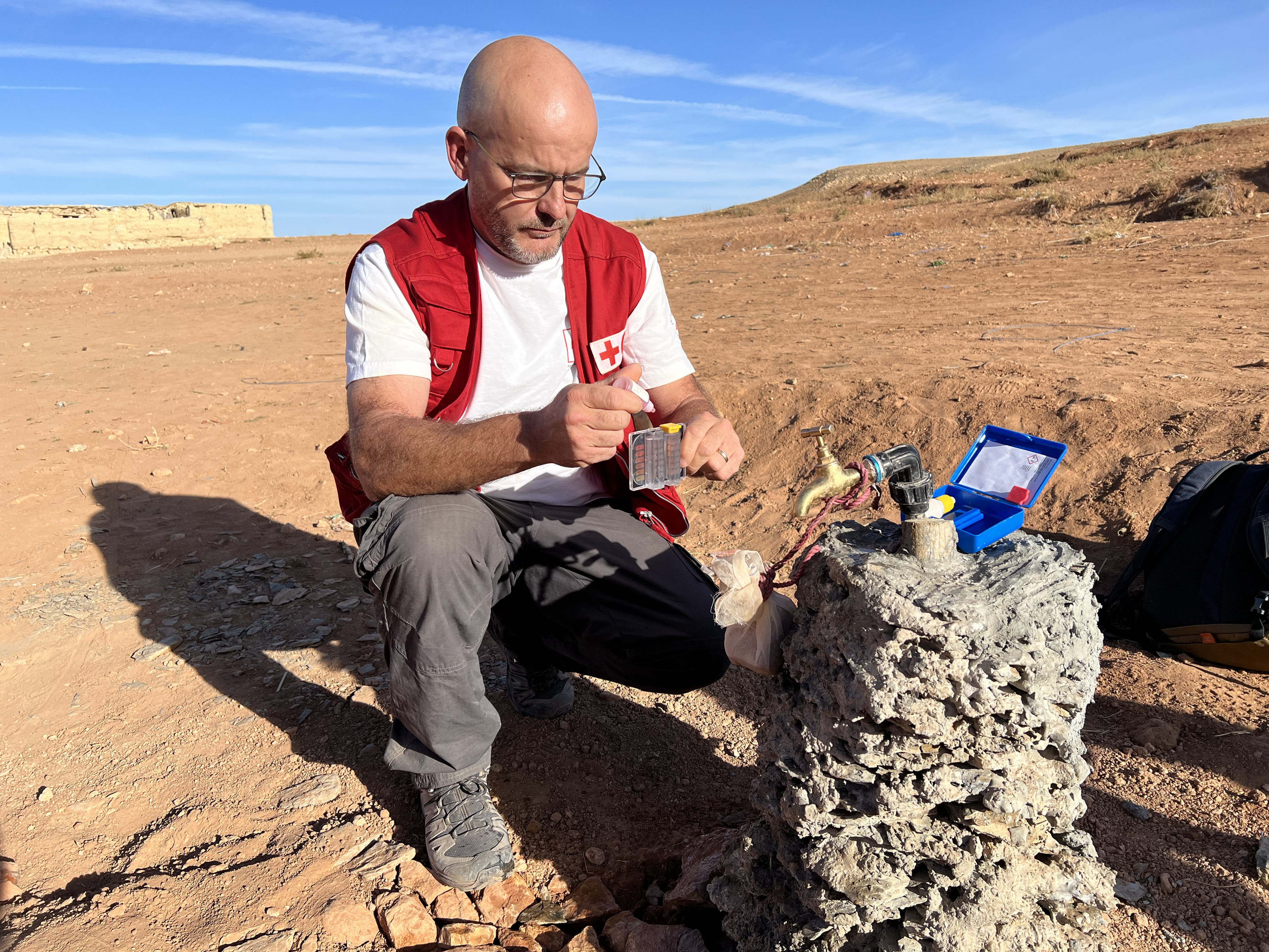 IFRC water, sanitation and hygiene delegate Gregory Gonzalez tests the quality of a newly installed water point in a remote Moroccan village following the September 2023 earthquake.