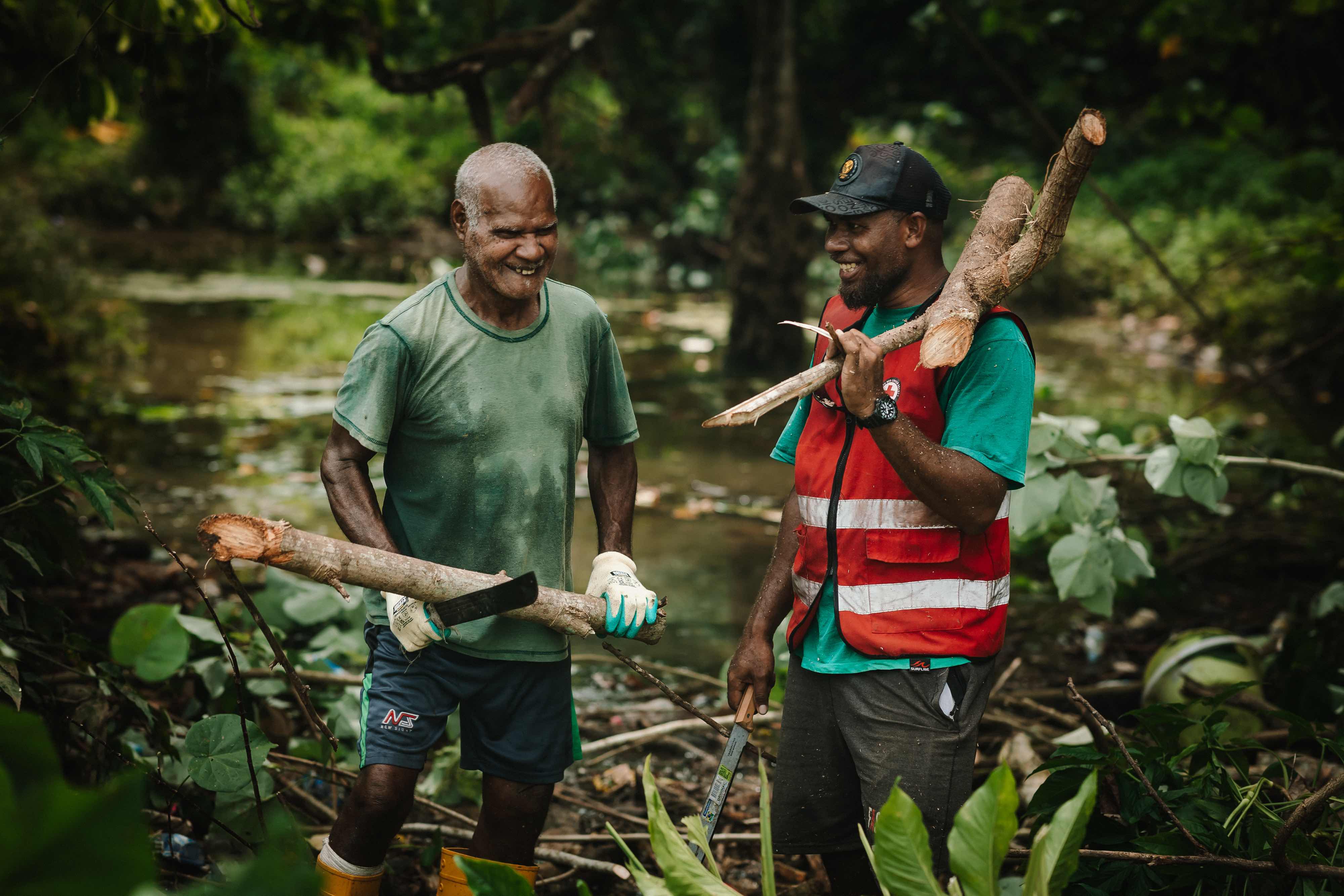 Local resident Jean Philipe Clement and a Vanuatu Red Cross volunteer clear wood and debris from a river bed just outside of Solwe, a community of 900 people in Vanuatu. During heavy rains, blockages caused by debris sometimes lead to dangerous and damaging floods.