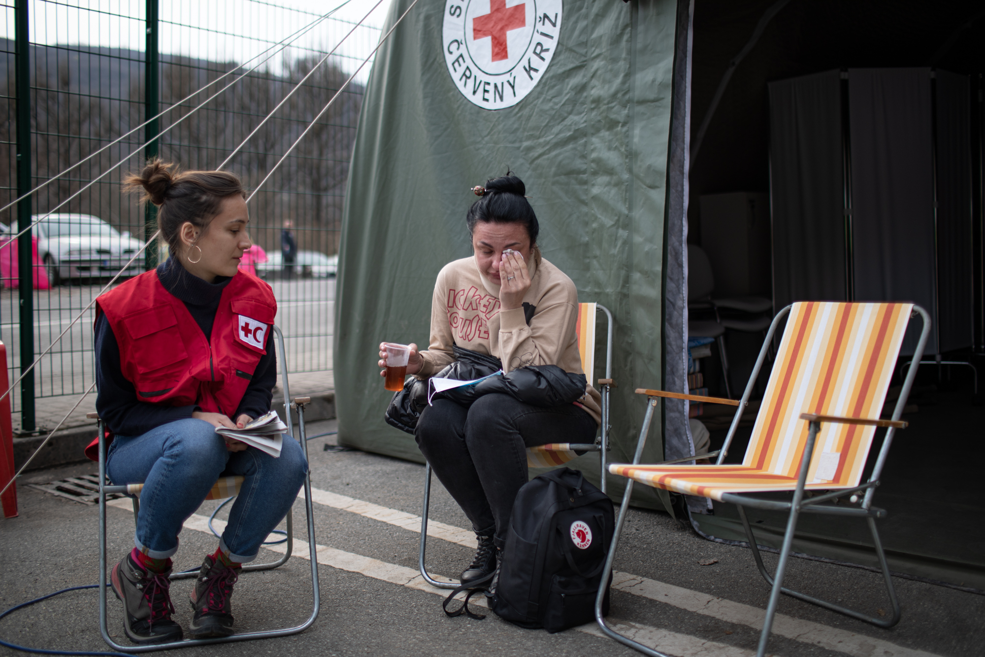 À la frontière slovaque avec l'Ukraine, une réfugiée ukrainienne nommée Iryna est réconfortée par un délégué de l'IFRC dans un poste de la Croix-Rouge slovaque mis en place pour aider les réfugiés en leur apportant les premiers soins, un soutien psychosocial et divers autres services essentiels pour les familles fuyant le conflit.
