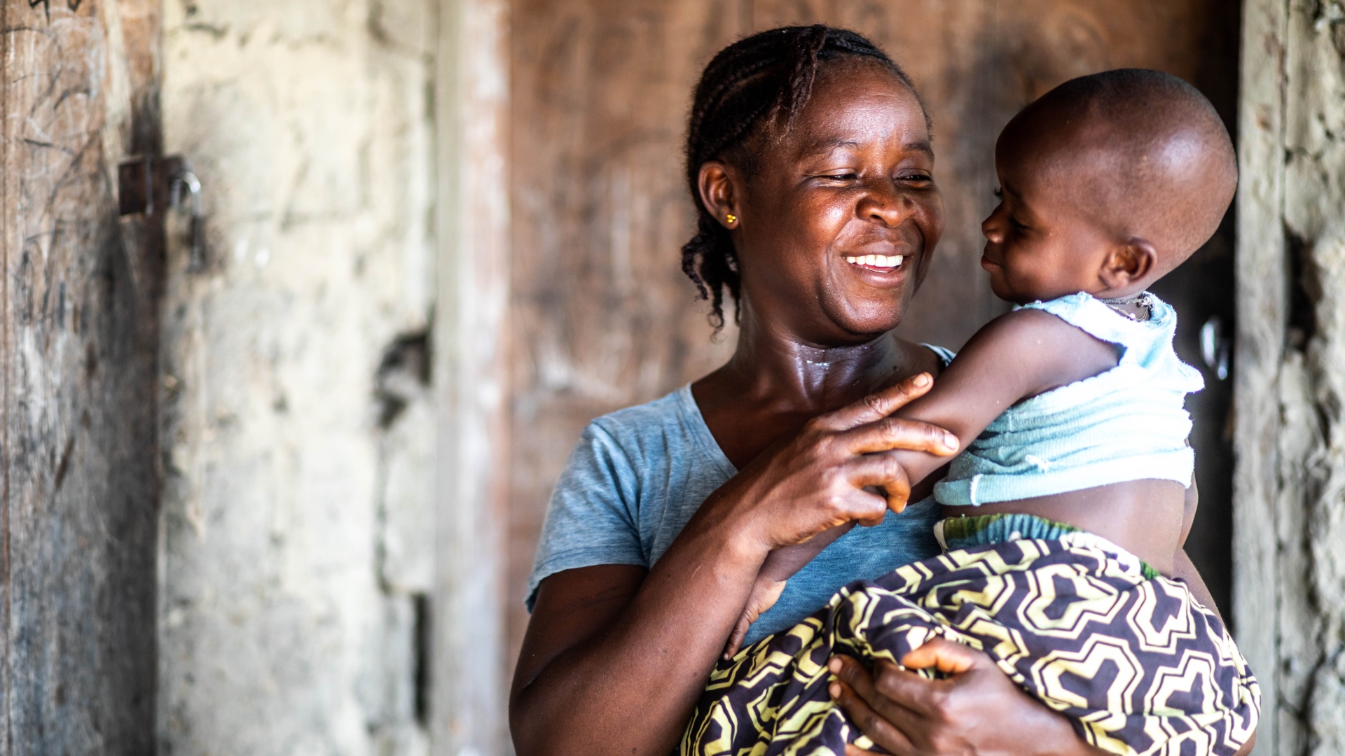 Baindu from eastern Sierra Leone holds her baby boy, Senesie, who recovered from acute malaria thanks to the help and quick action of a Sierra Leone Red Cross Society volunteer.