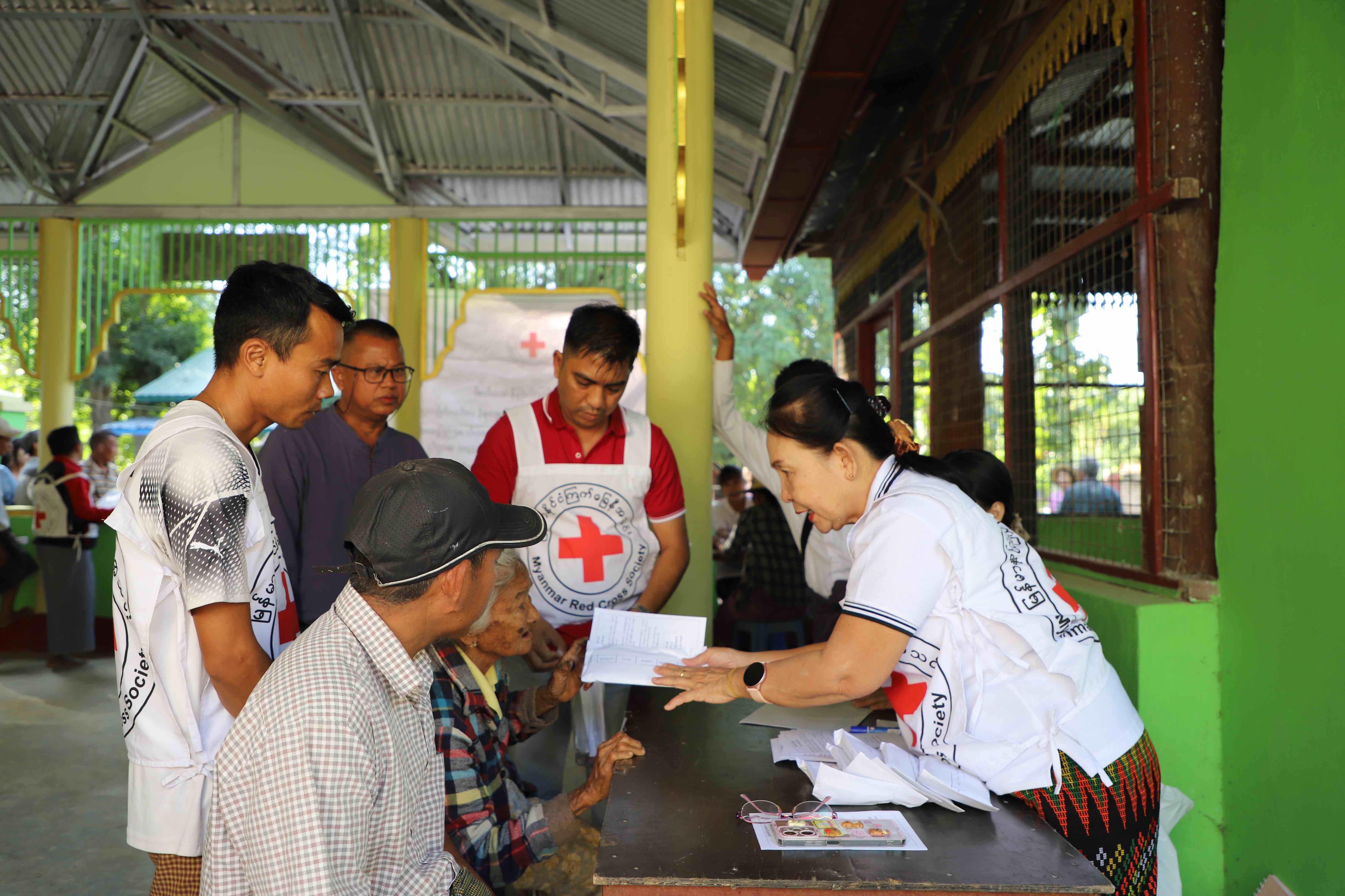 Dr. Chaw Khin talks with people impacted by Cyclone Mocha in 2023 during a cash distribution aimed at helping them get back on their feet after the storm. 