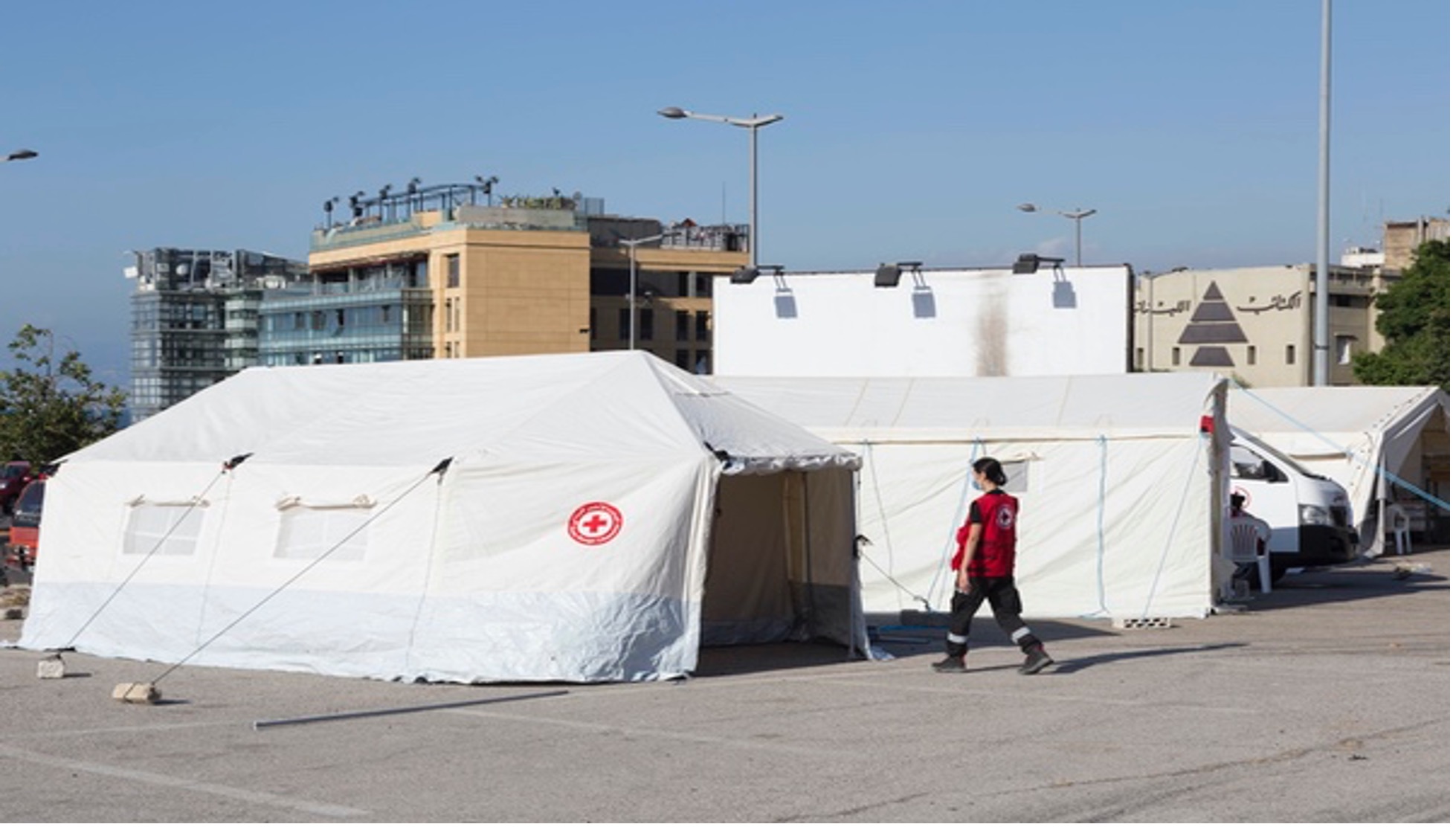 Members of the Lebanese Red Cross Humanitarian Service Point team that responds to shipwrecked migrants stand outside their response vehicles.