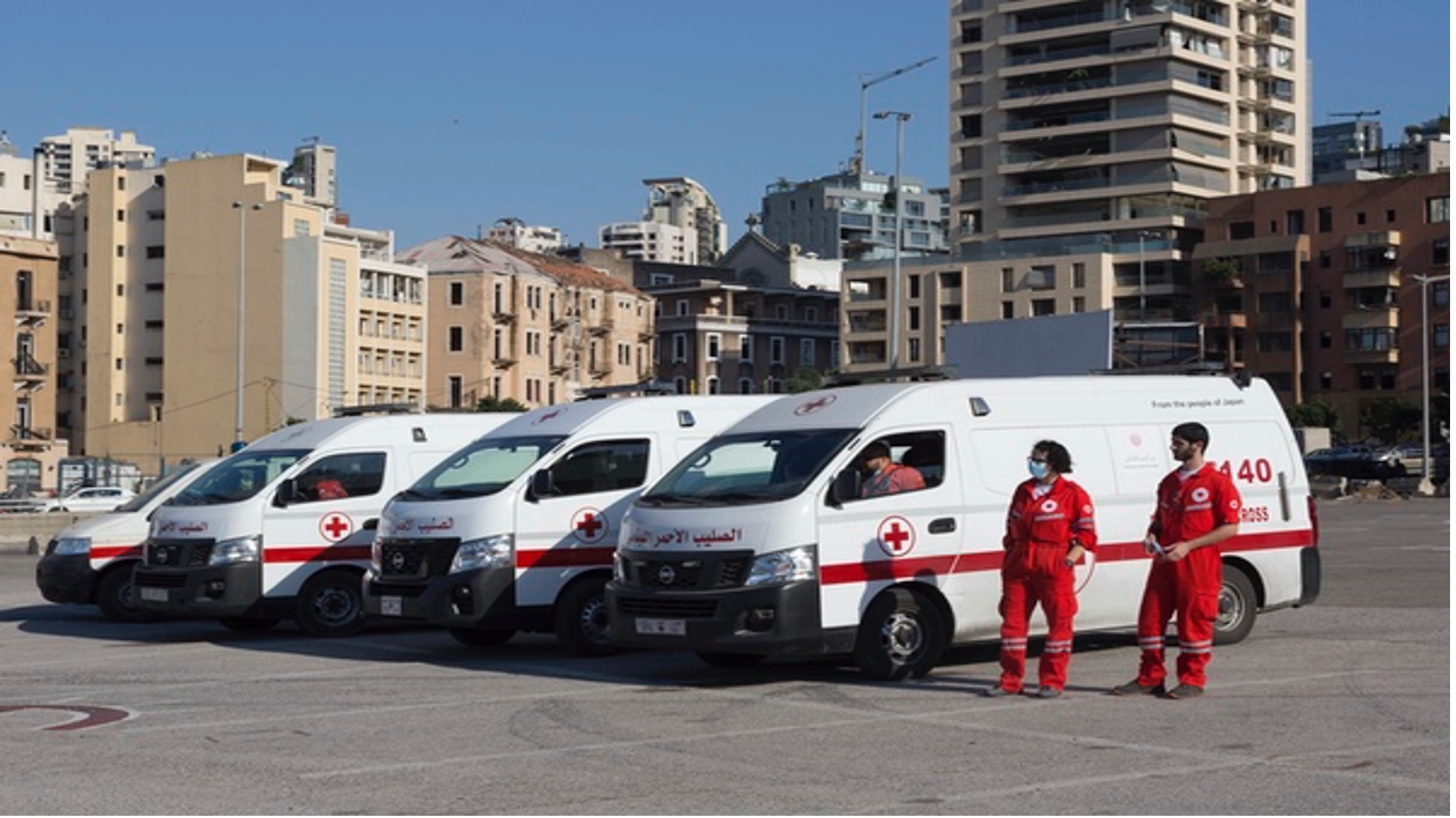 Members of the Lebanese Red Cross Humanitarian Service Point team that responds to shipwrecked migrants stand outside their response vehicles.