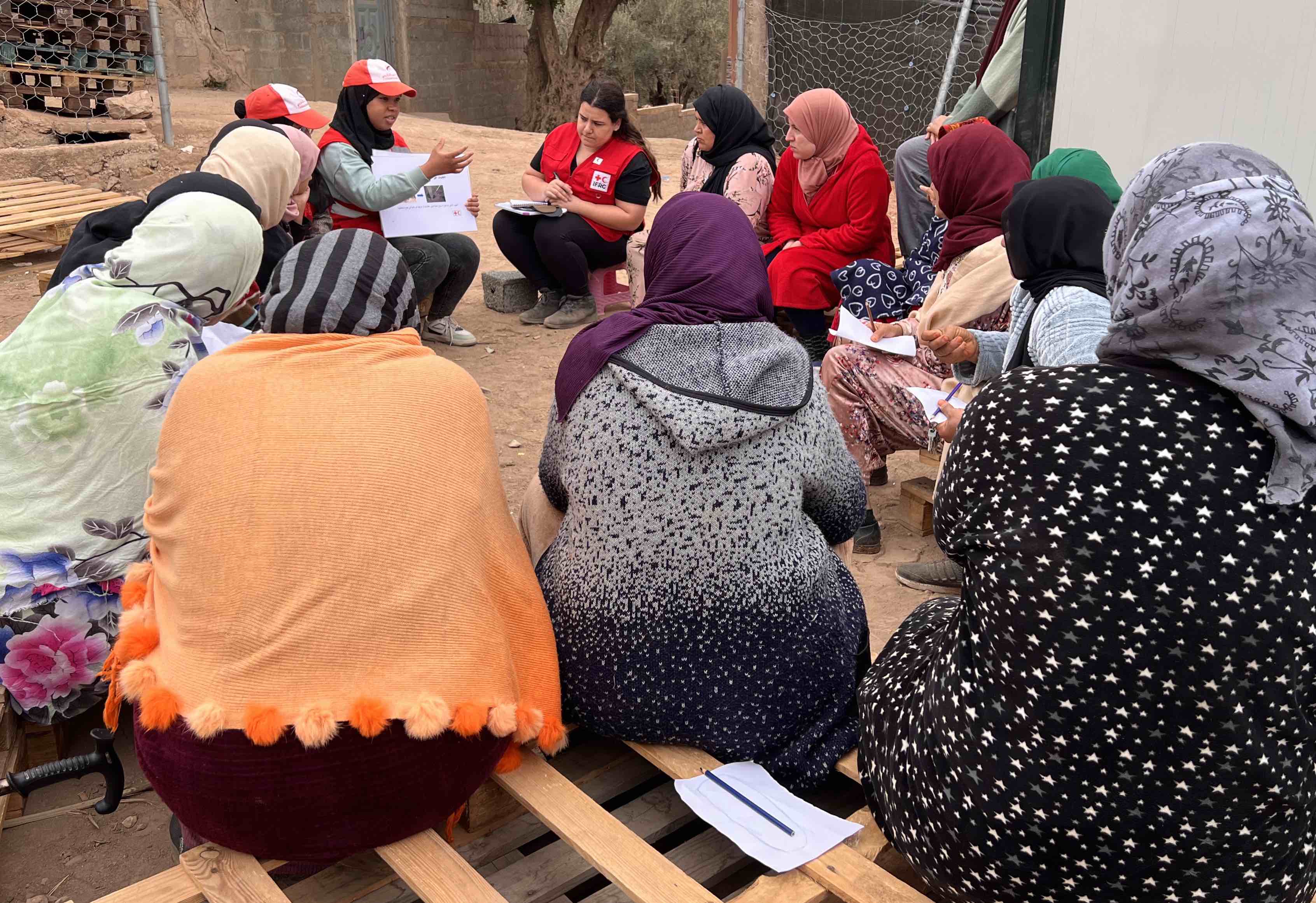 A Moroccan Red Crescent volunteer talks to a dozen women from the village of Ait Youssef about the process of making their own menstrual hygiene products.