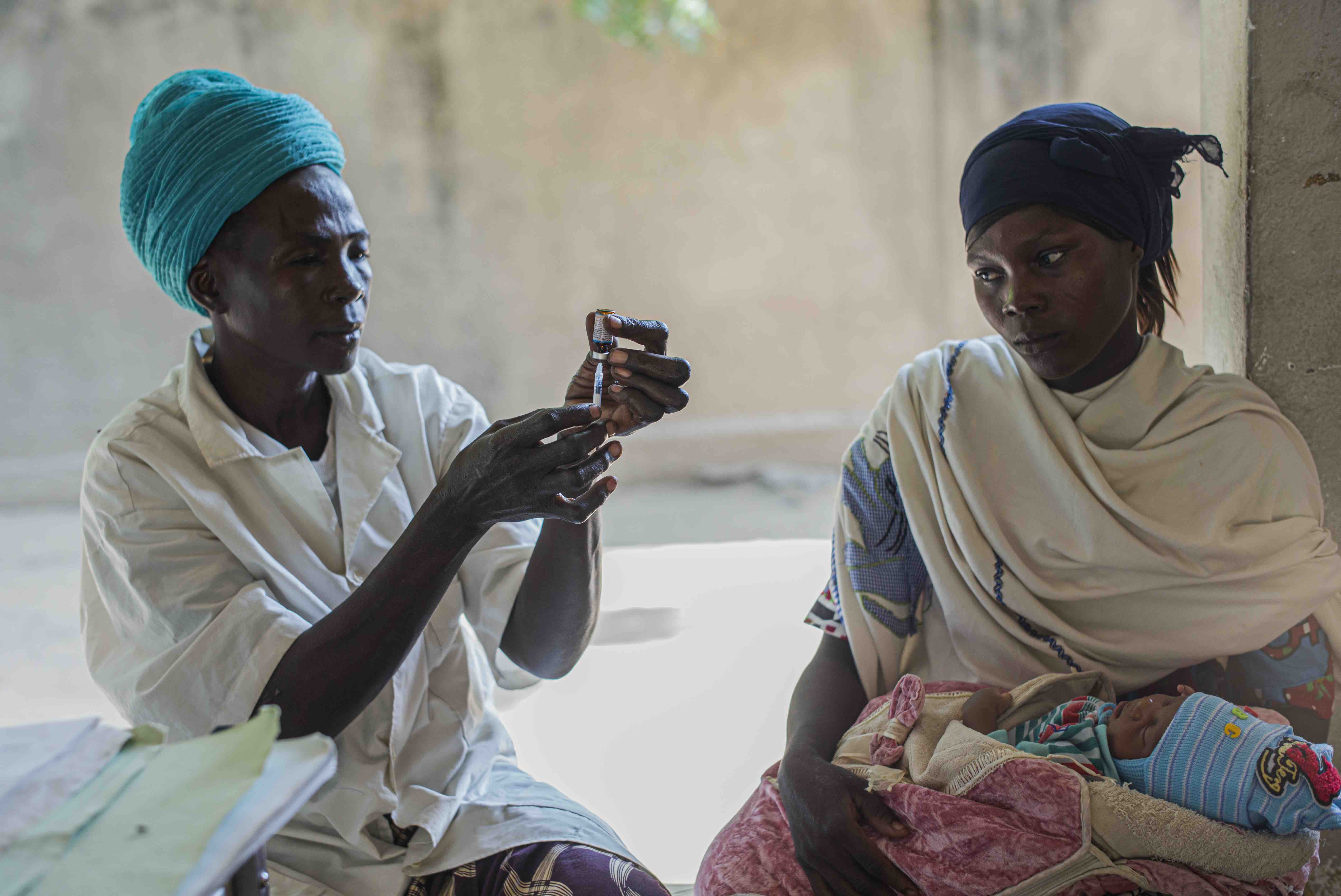 A mother watches on as a health worker in Bongor, Chad, immunizes her child.