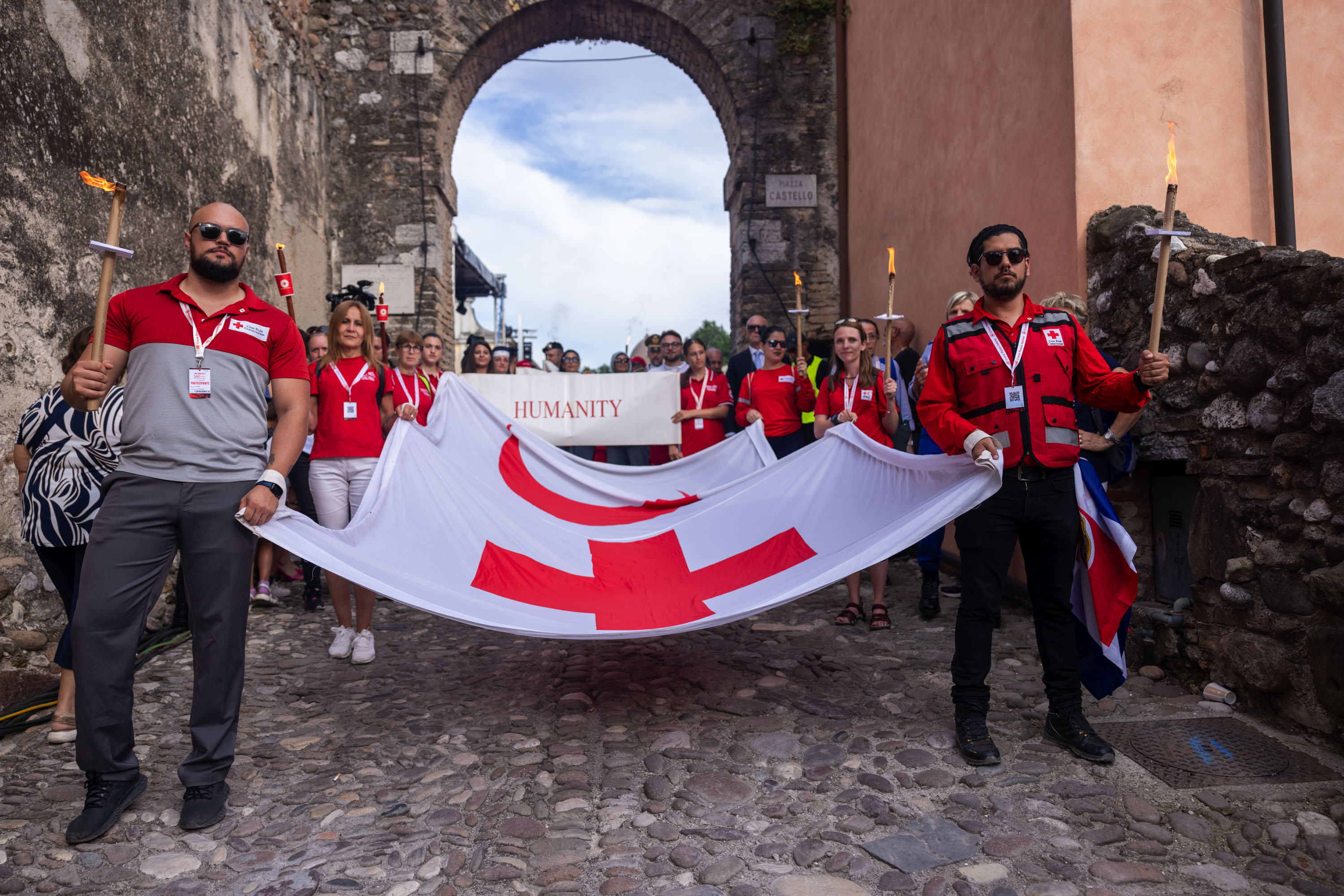 Red Cross and Red Crescent staff carry an IFRC flag as they following the steps taken by the women of Castiglione delle Stiviere in the aftermath of the bloody Battle of Solferino on June 24, 1859.