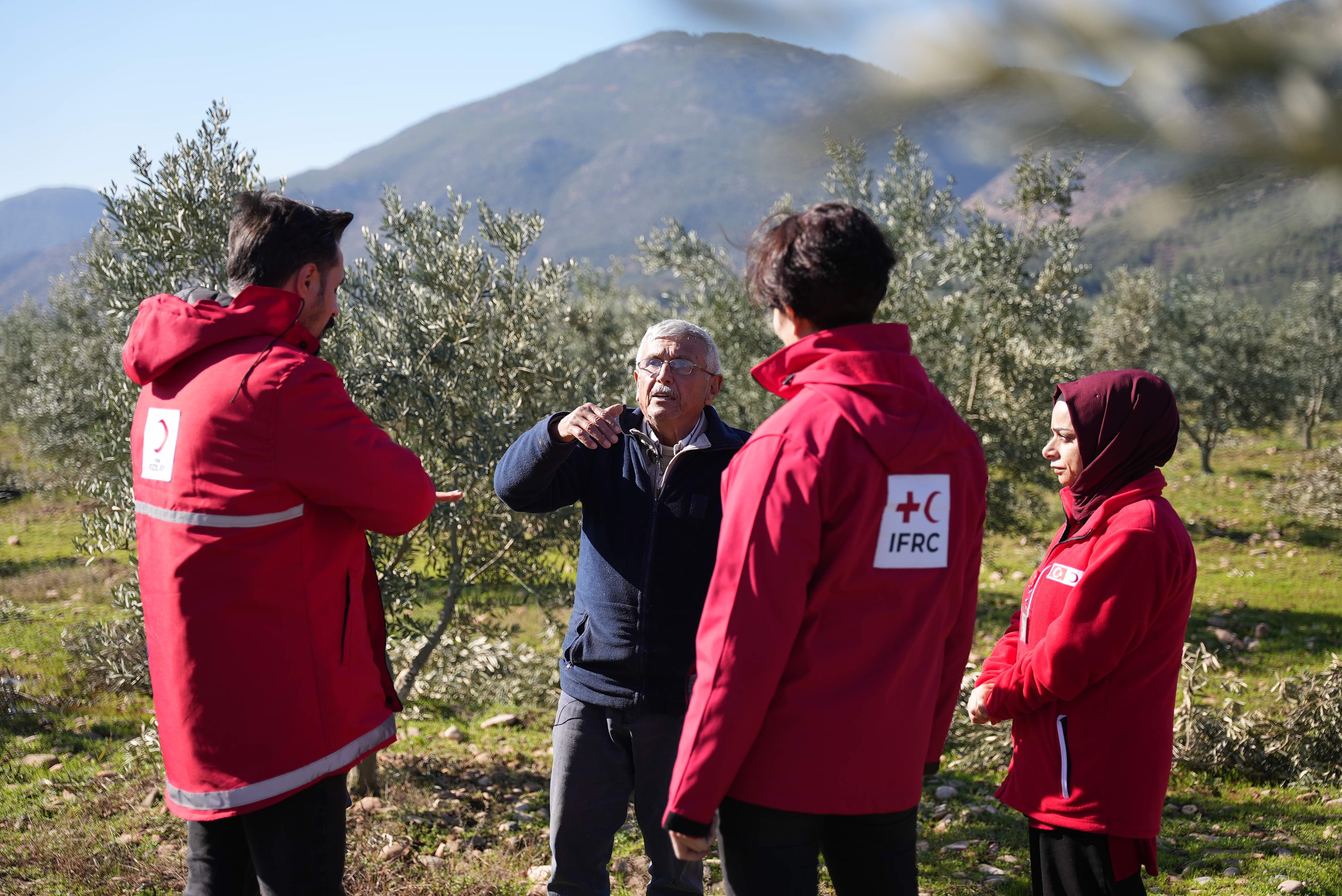 Ali Öztürk, a farmer from Gaziantep province, stands in his olive orchard with members of the Turkish Red Crescent and the IFRC.