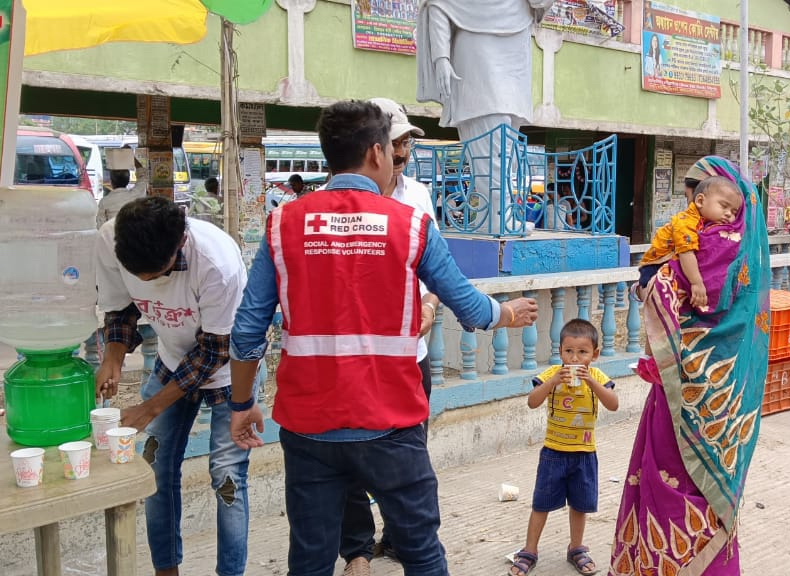Volunteers for the Indian Red Cross hand out bottles of water and share information about how to stay healthy during heatwaves.