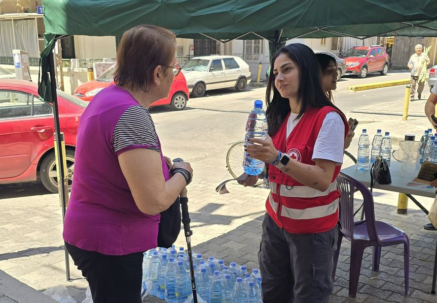A Lebanese Red Cross volunteer shares a water bottle and valuable information about protection from heatwaves. It’s part of a comprehensive plan to get ahead of heatwave season.