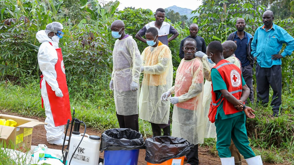 Trained Uganda Red Cross teams put on personal protective equipment in preparation for performing a safe and dignified burial during the 2022 Ebola outbreak.