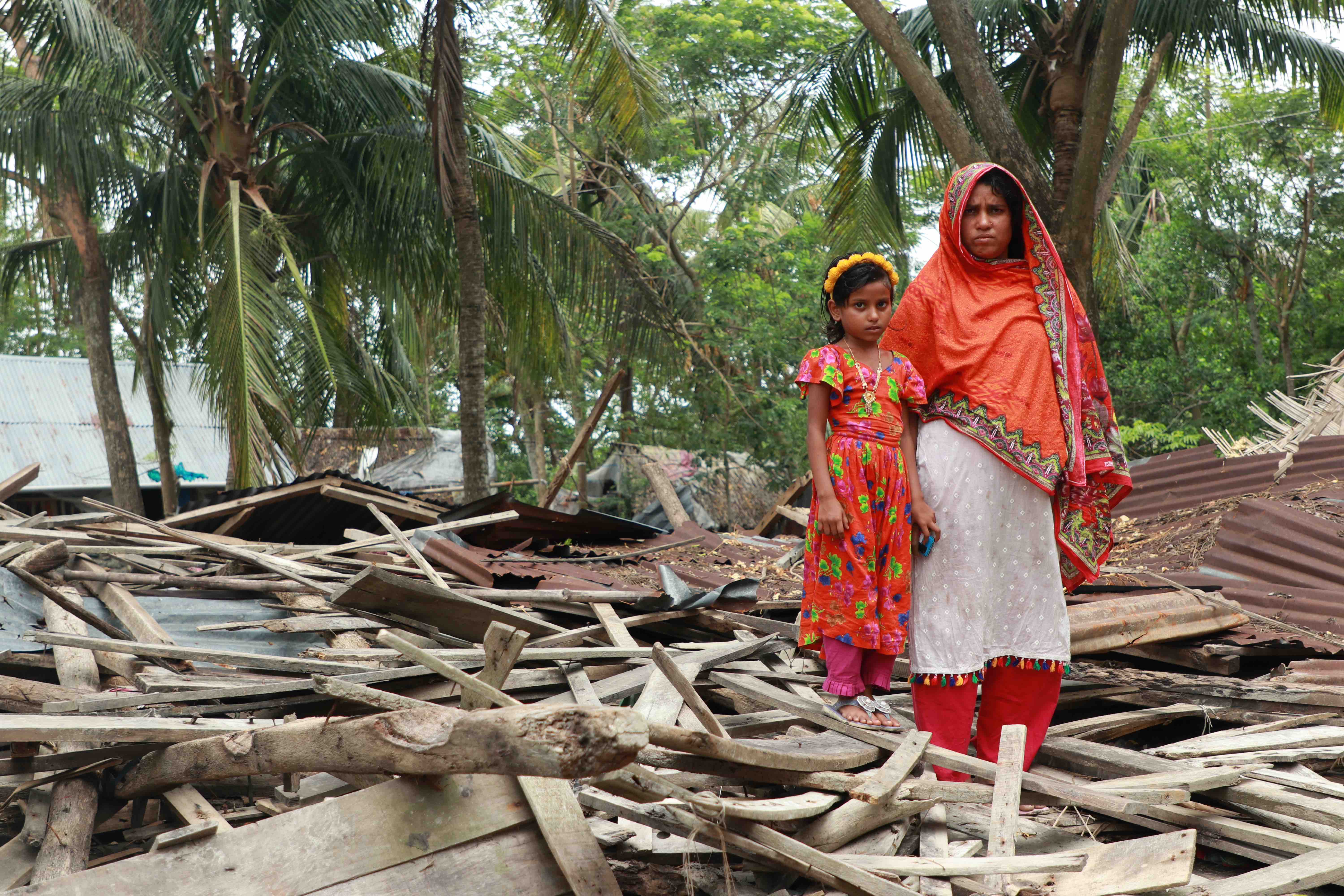 Along with one of her daughters, 35-year-old Tanya stands on top the remains of her family’s home