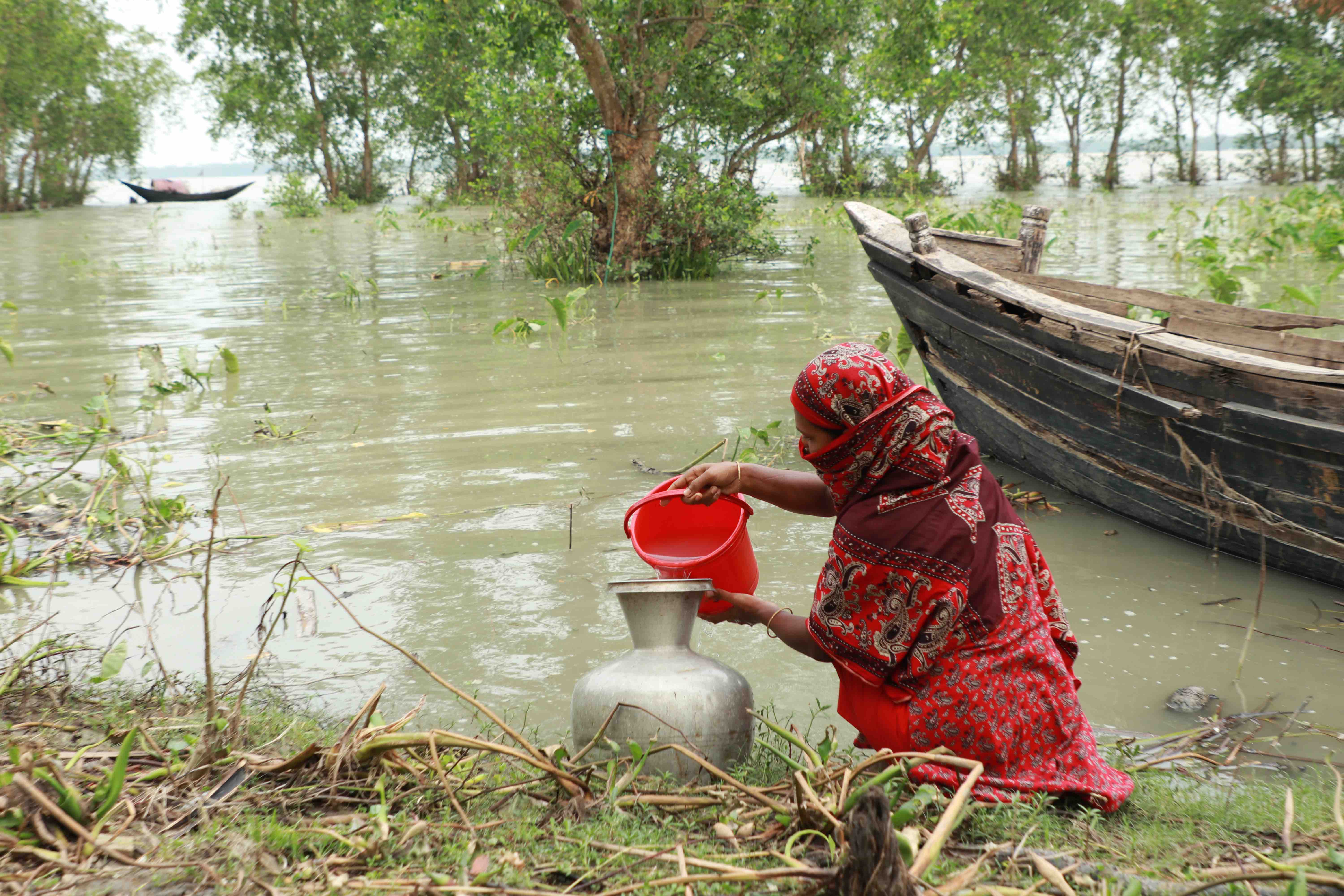 A woman gets salty water from the river estuary, the only recourse after Cyclone Remal destroyed regular sources of clean water.  Access to clean water is critical, as over 20,000 water points and more than 134,000 latrines were damaged by the storm. 