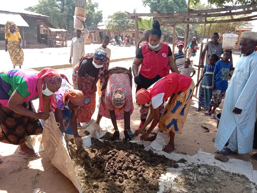 Nigerian Red Cross volunteer Saratu Aboki works with women to make compost they can use in their gardens. 