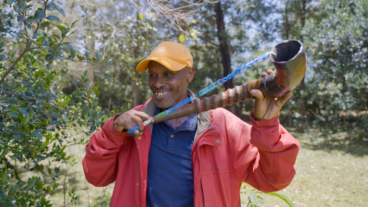 Augustine Langat from Kipajit village, Kenya, smiles as he holds his Kigondit - a traditional horn used by the Kipsigis people to summon their community.