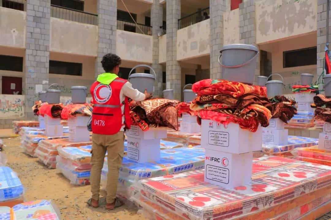 Un voluntario de la Media Luna Roja de Yemen apila suministros domésticos que serán entregados a las personas que perdieron sus hogares debido a las graves y repentinas inundaciones.