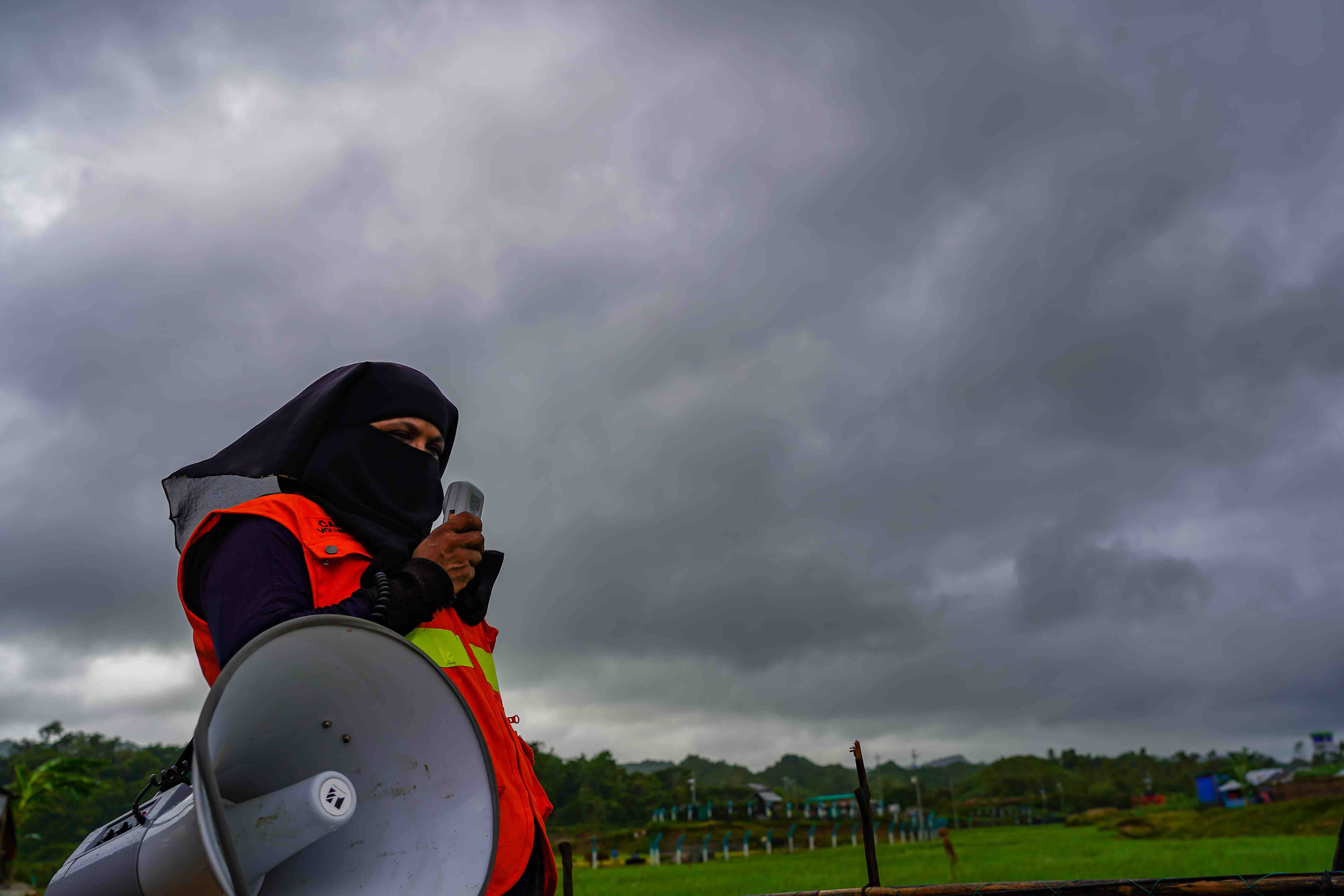 Bangladesh Red Crescent volunteer Dil Kayas uses a megaphone to share critical storm-warning information with residents of the Cox’s Bazar settlement in Bangladesh.