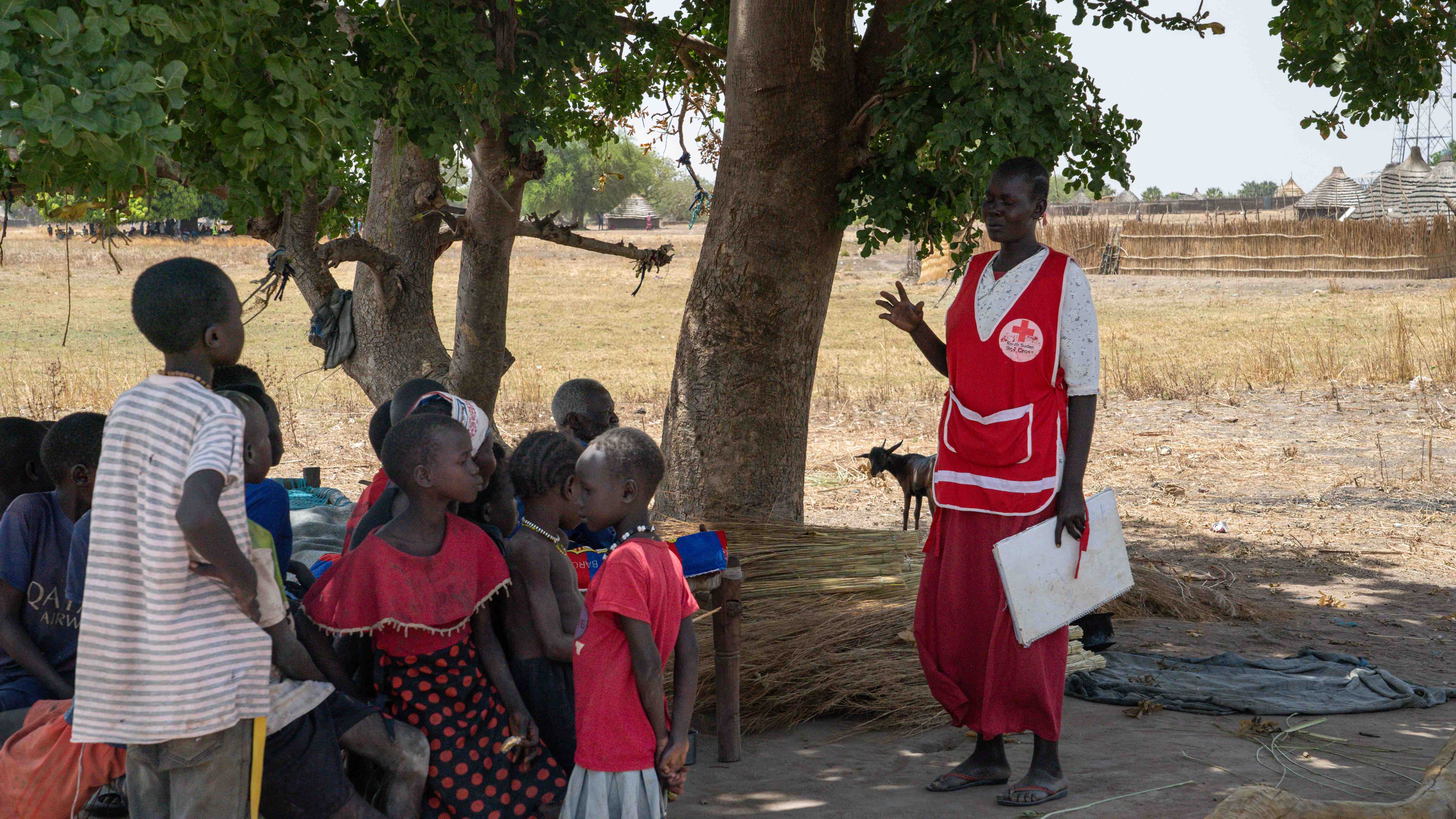 Adut Wek Wol, a volunteer at the South Sudan Red Cross, teaches a group of children about the risks and spread of diseases, as well as essential hygiene practices.