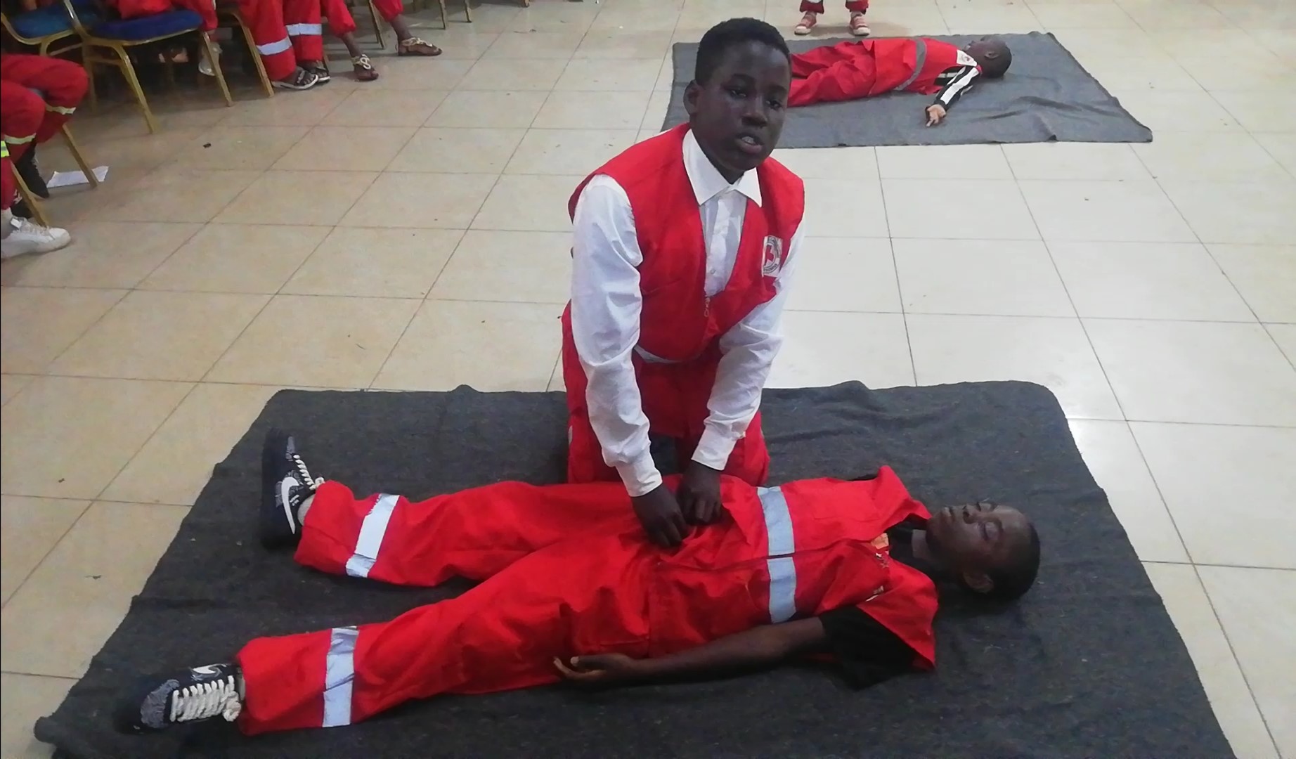Two Cameroon Red Cross volunteers take part in a first-aid learning camp where they learn how to respond when someone is injured, bleeding, choking or suffering from a heart attack.
