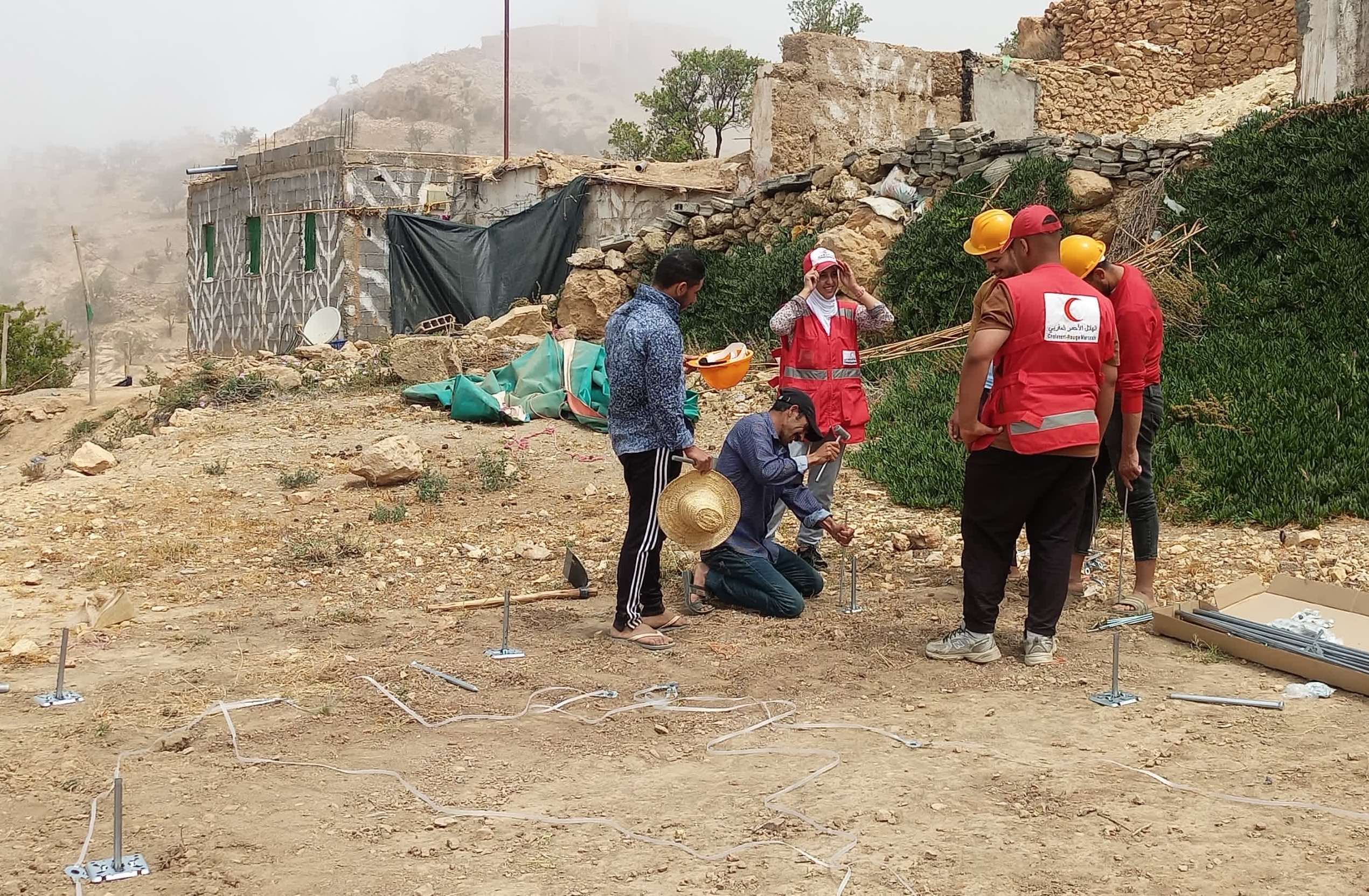 Naima and other Moroccan Red Crescent shelter team members training community workers on how to install temporary shelter units in the community of Ighzran, which has heavily impacted by the earthquake. 