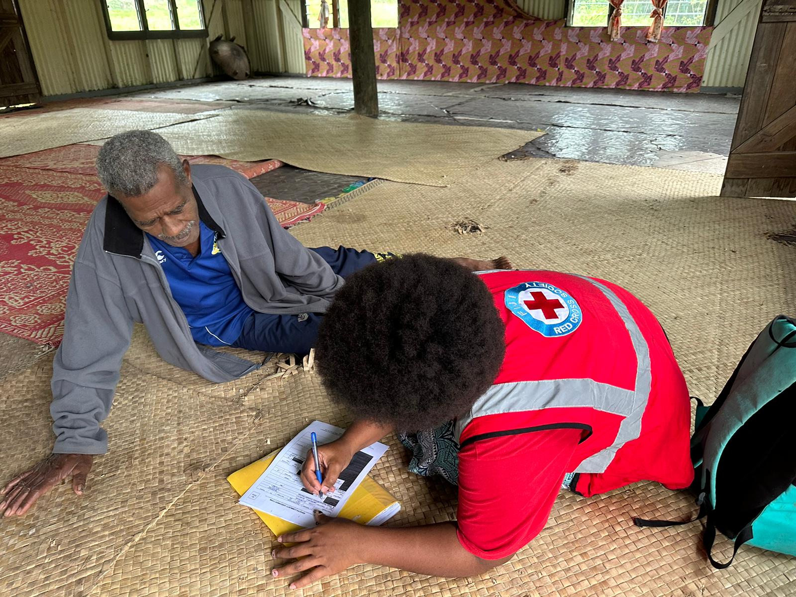 A Fiji Red Cross volunteer talks to a local resident as part of a Dengue Fever awareness campaign.