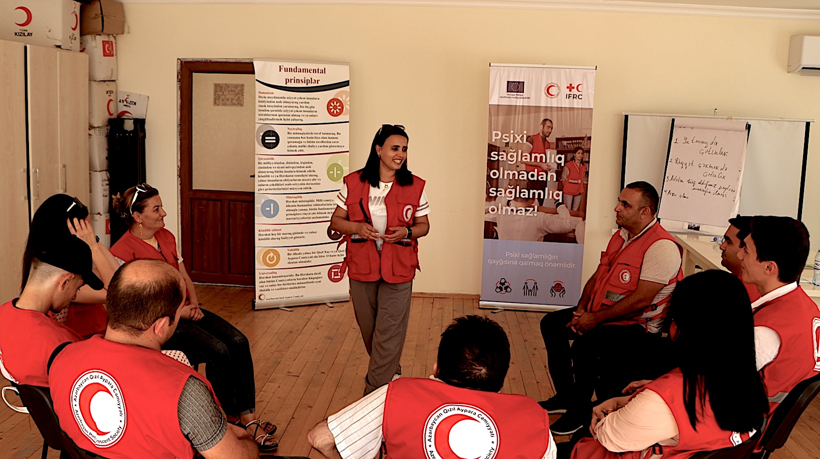Gunel Abbasova, de la Media Luna Roja de Azerbaiyán, habla con otras personas voluntarias durante una sesión de formación en salud mental.