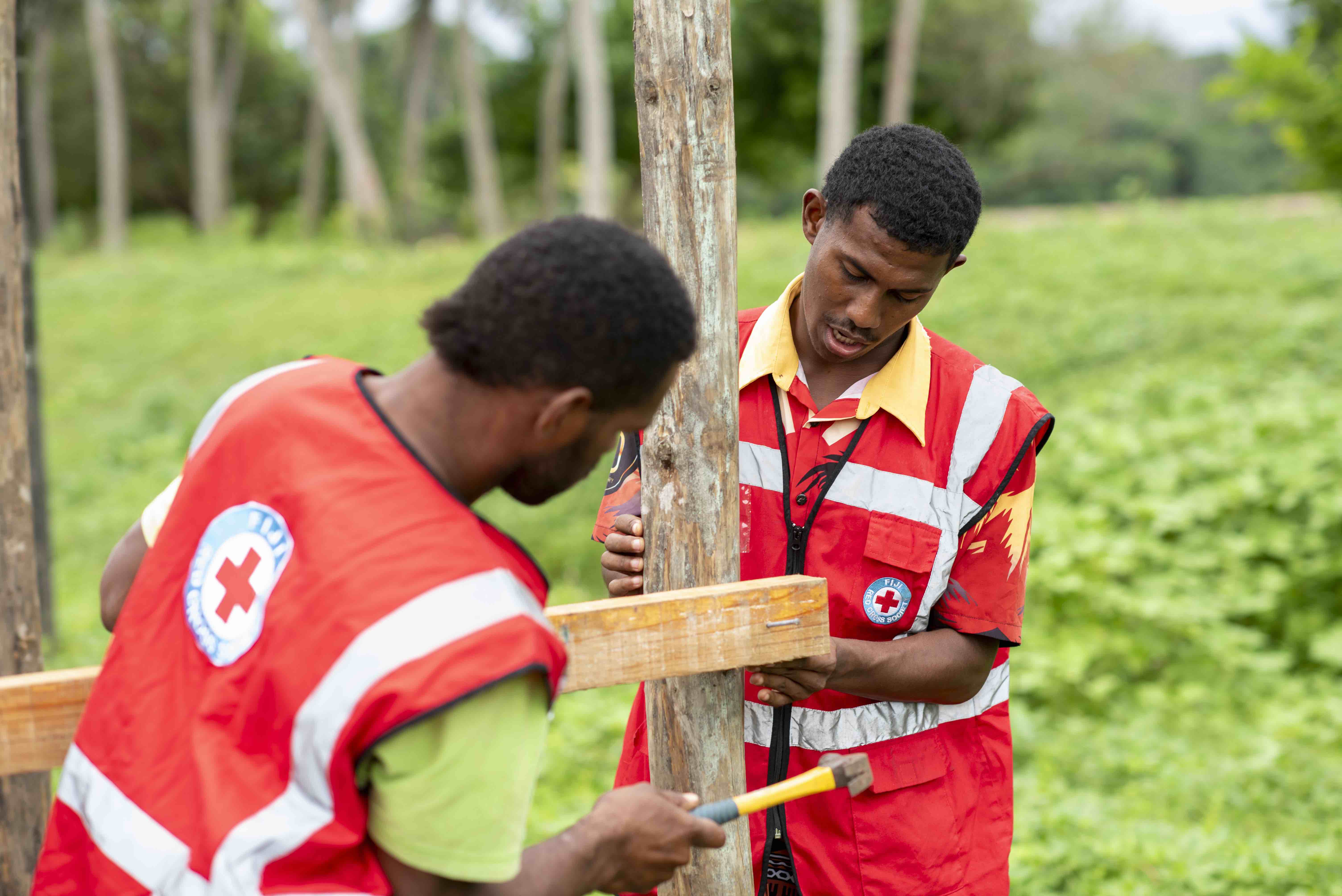  Fiji Red Cross youth volunteers build a rubbish bin as part of efforts to keep waterways clear of debris that might cause blockages and worsen the impacts of floods.
