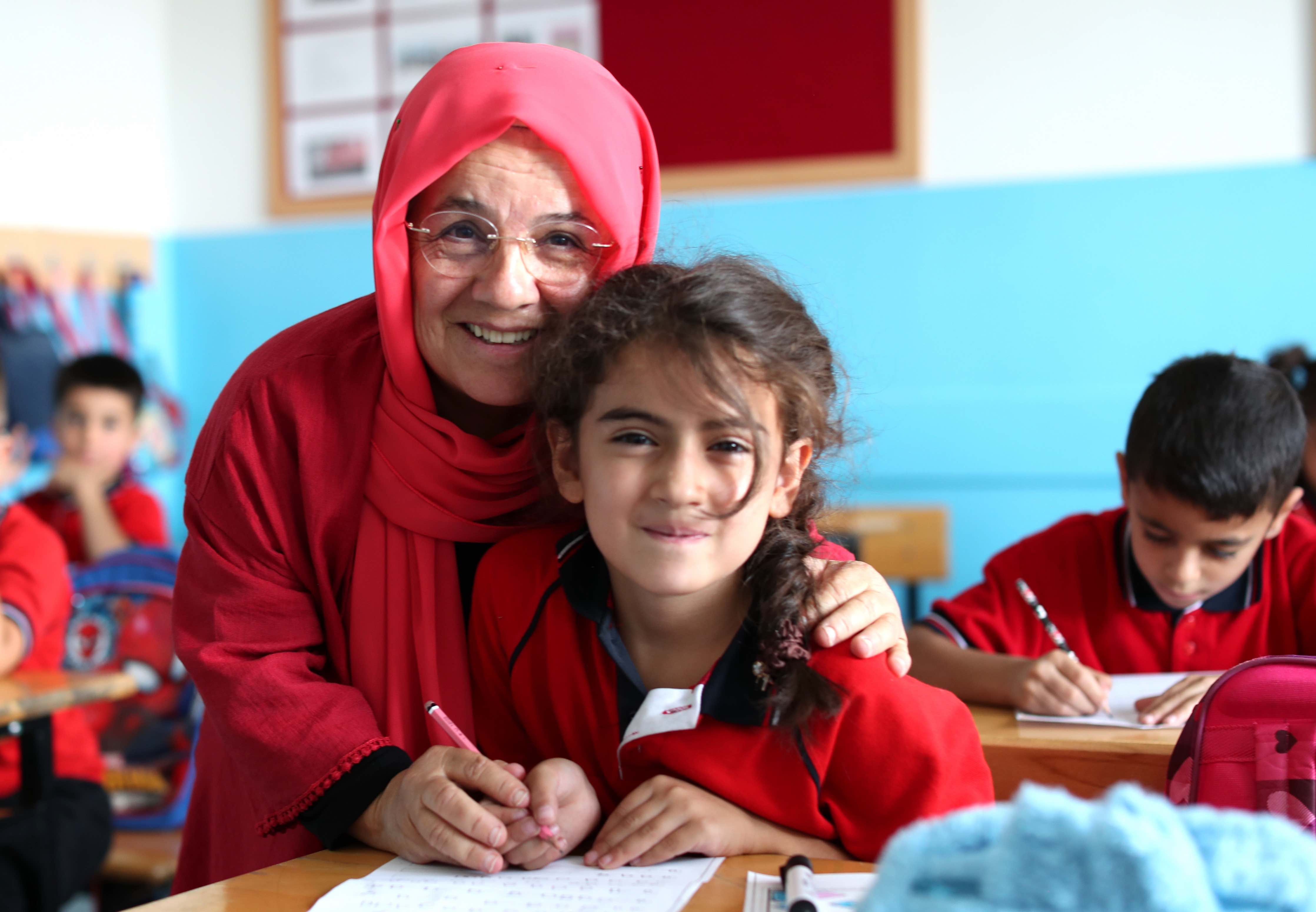 A teacher who has dedicated her life to breaking down barriers for people with disabilities, Gülhan Ince smiles as she helps a young student with her classwork.