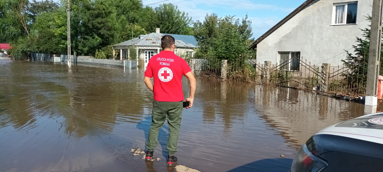 A volunteer with the Romanian Red Cross surveys the damage caused by recent flooding.