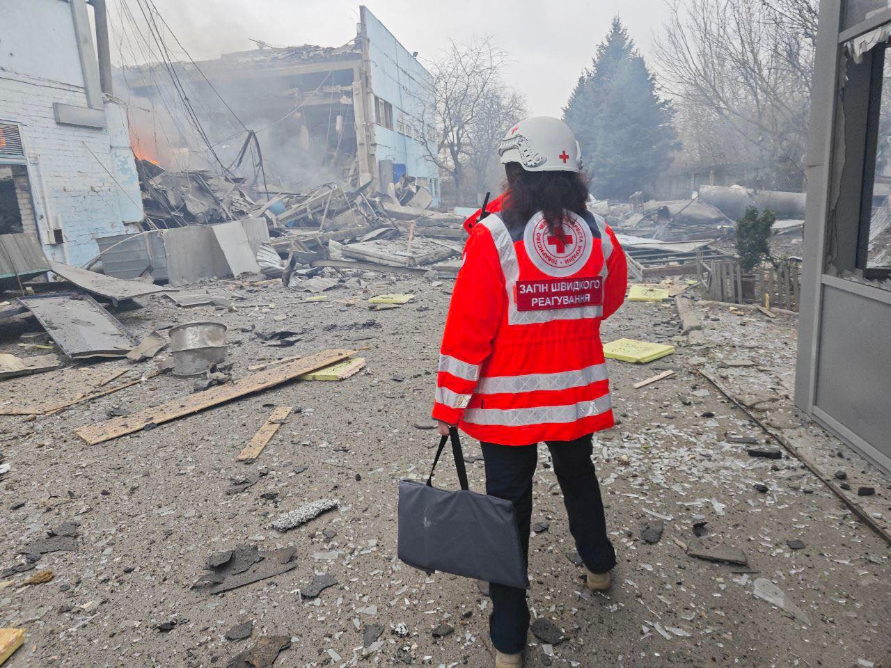 Ukraine Red Cross volunteer inspects damage after a bombardment.
