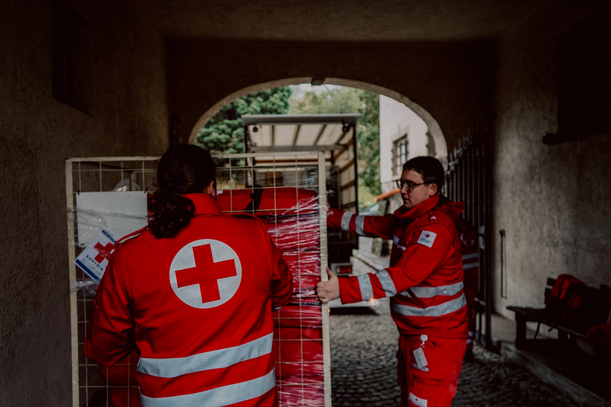 Volunteers with the Austrian Red Cross prepare supplies to be loaded on a truck for distribution.