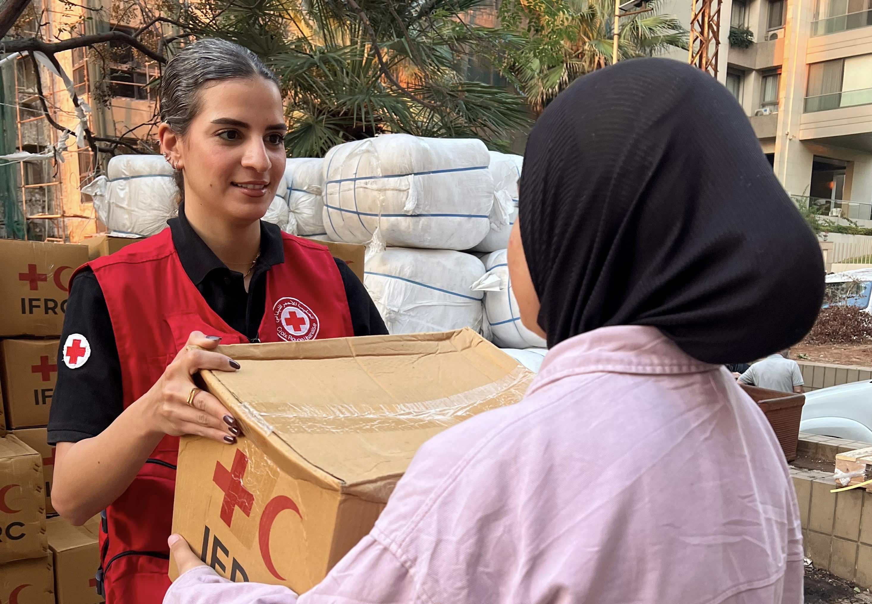 متطوعة في الصليب الأحمر اللبناني تقدم إمدادات الإغاثة للنازحين بسبب الصراع المتواصل. 