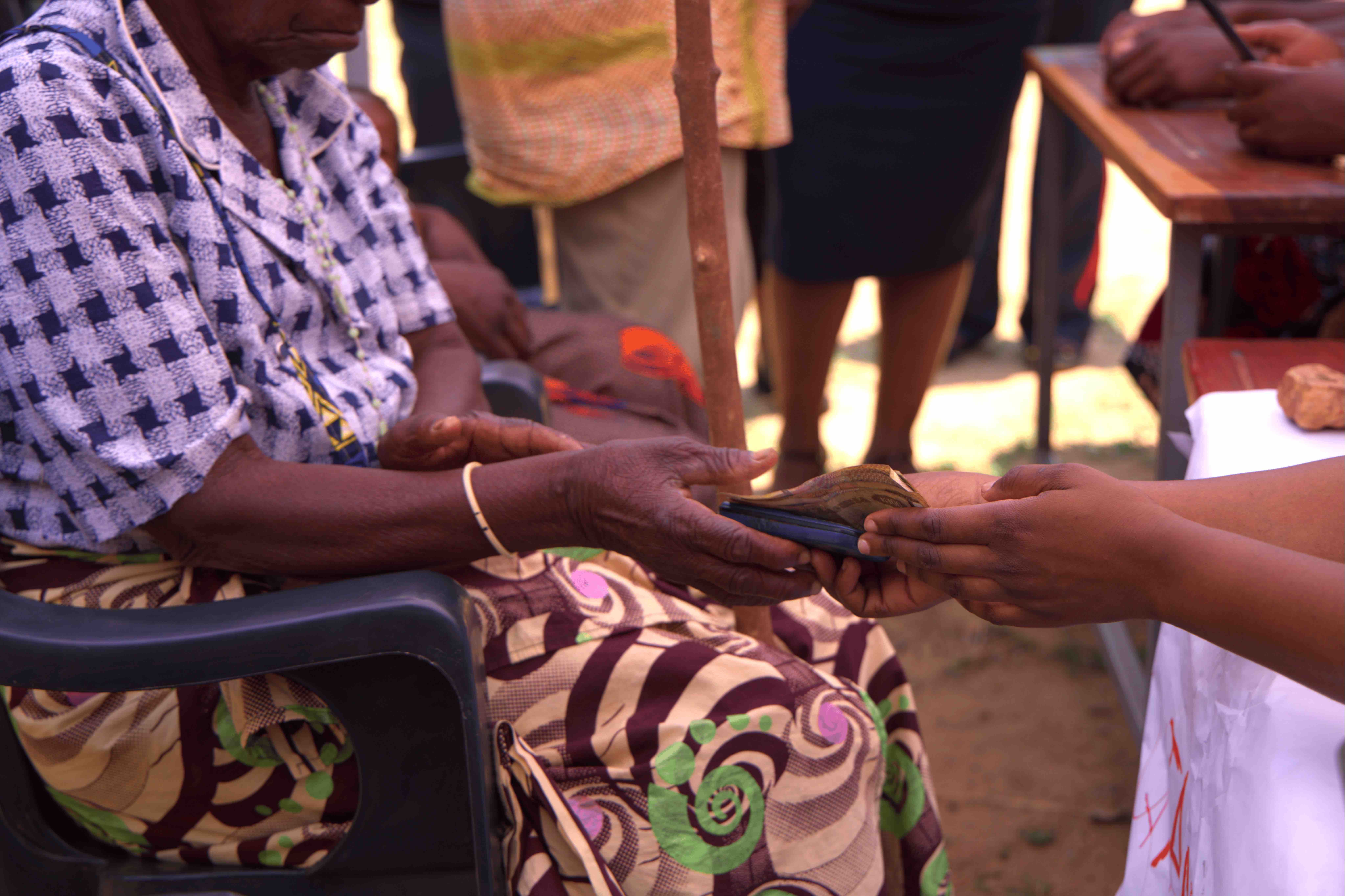 A woman receives cash as part of a cash assistance programme being carried out in Chinkankata, near Zambia’s southern border with Zimbabwe. 