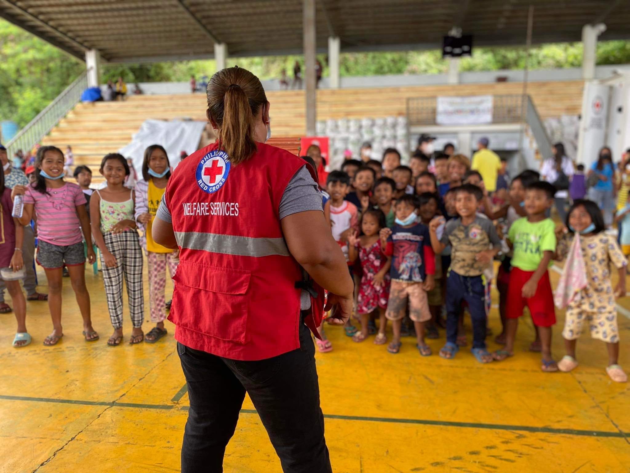 Philippine Red Cross Society volunteer Felisa Buquel leads children in singing and dancing activities in an evacuation centre set up after recent heavy storms.