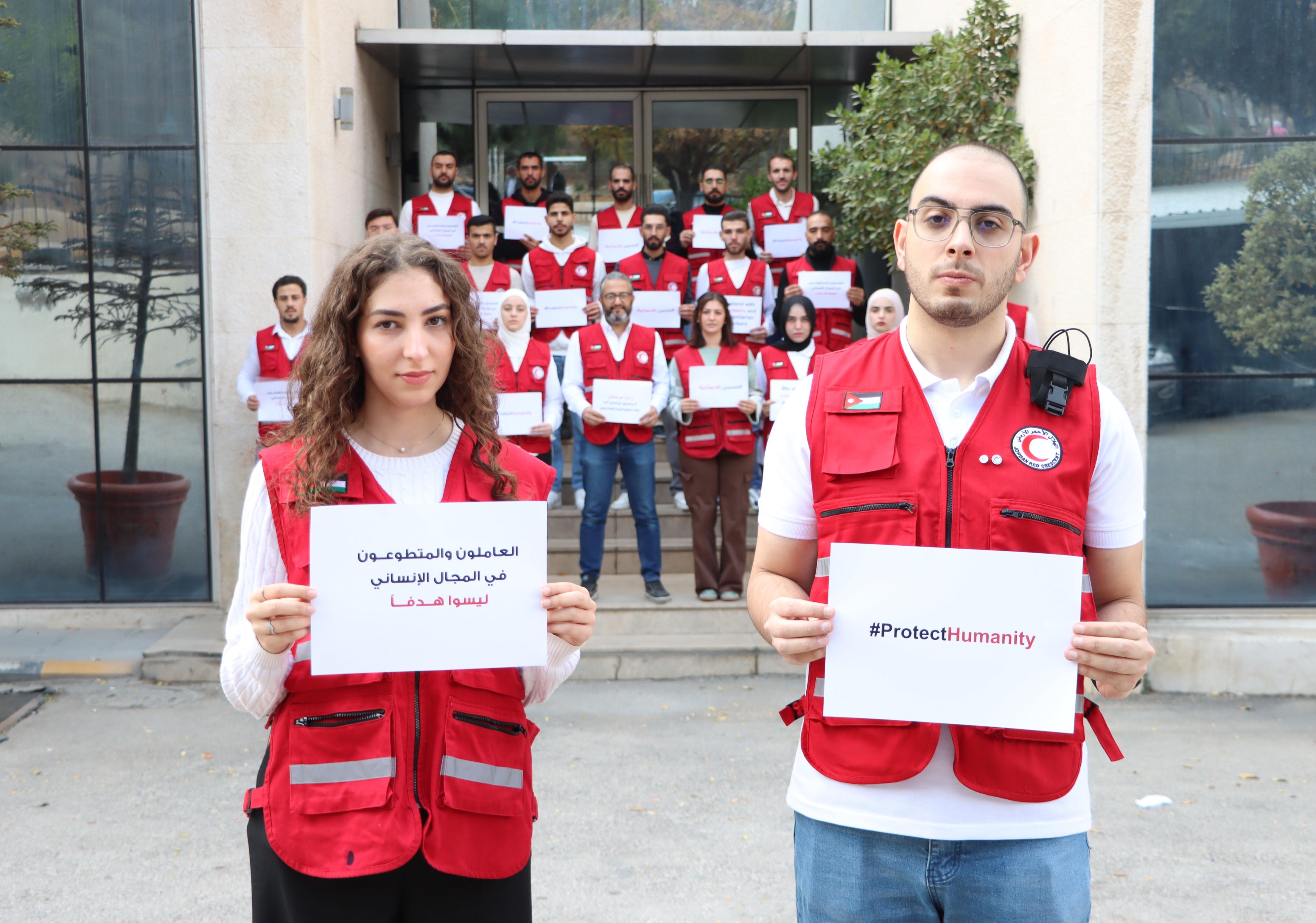 In front of their headquarters in Amman, Jordan, volunteers from the Jordan Red Crescent Society stand united behind the message of ‘Protect Humanity.’