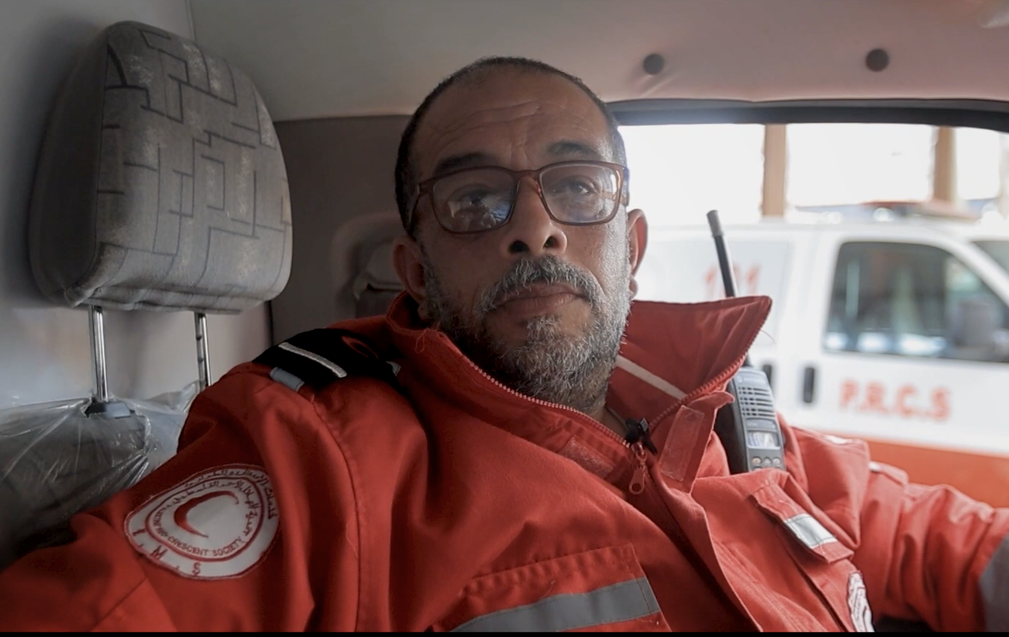 Palestine Red Crescent paramedic Kamal Ahmad sitting in the driver's seat of a Red Crescent ambulance.