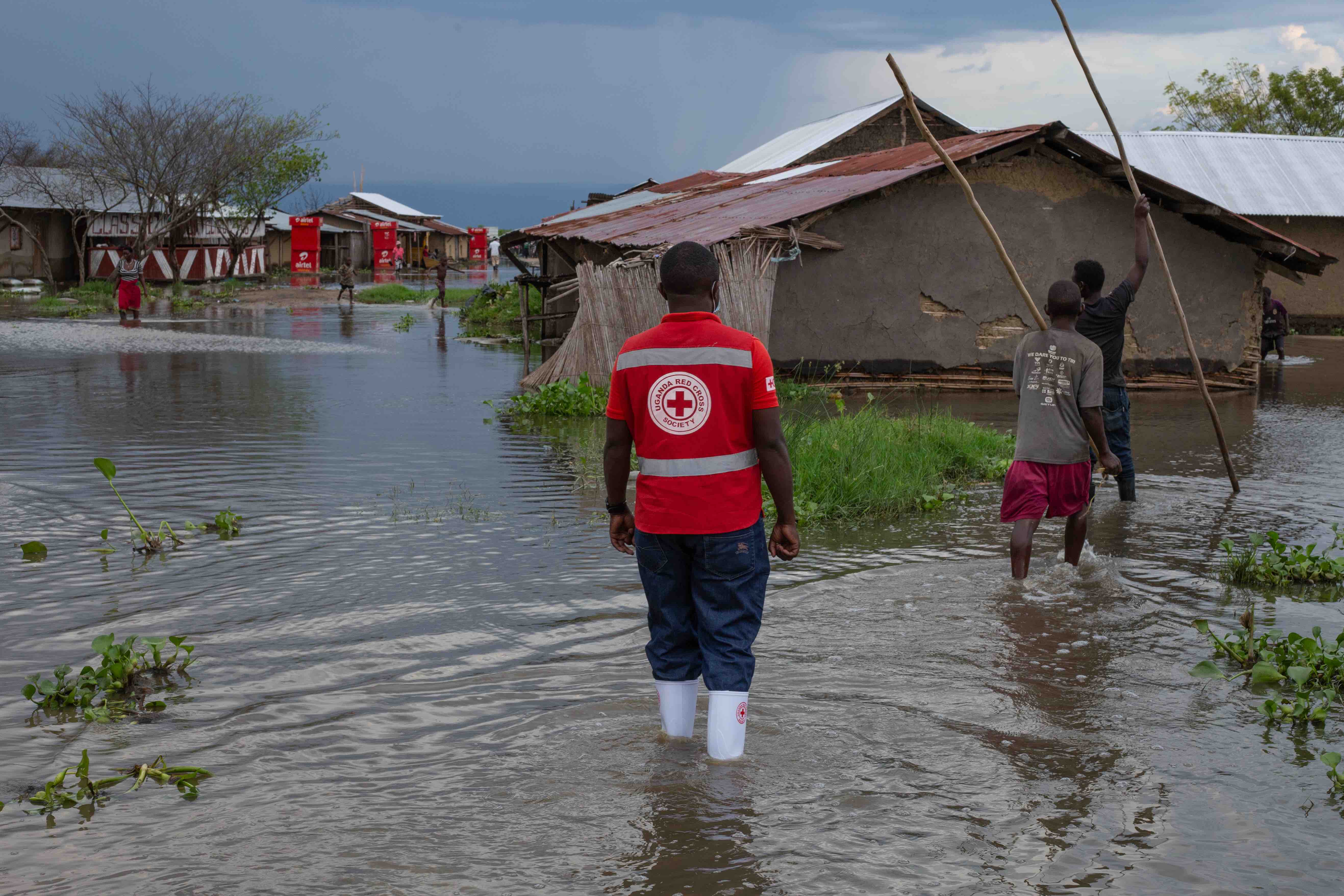 A volunteer from the Uganda Red Cross Society walk through a village inundated by floods, an increasing phenomenon in an era defined by abnormal weather patterns. A new tool is helping the Uganda Red Cross and communities better predict the impacts of climate events and reduce the human toll they take.