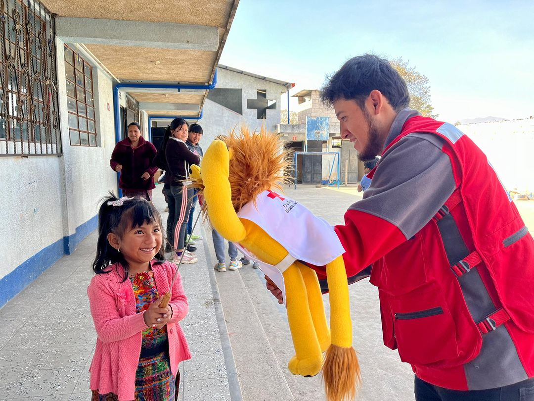 A volunteer for the Guatemalan Red Cross performs at a local school as part of a community theatre activity that teaches children about disease prevention.