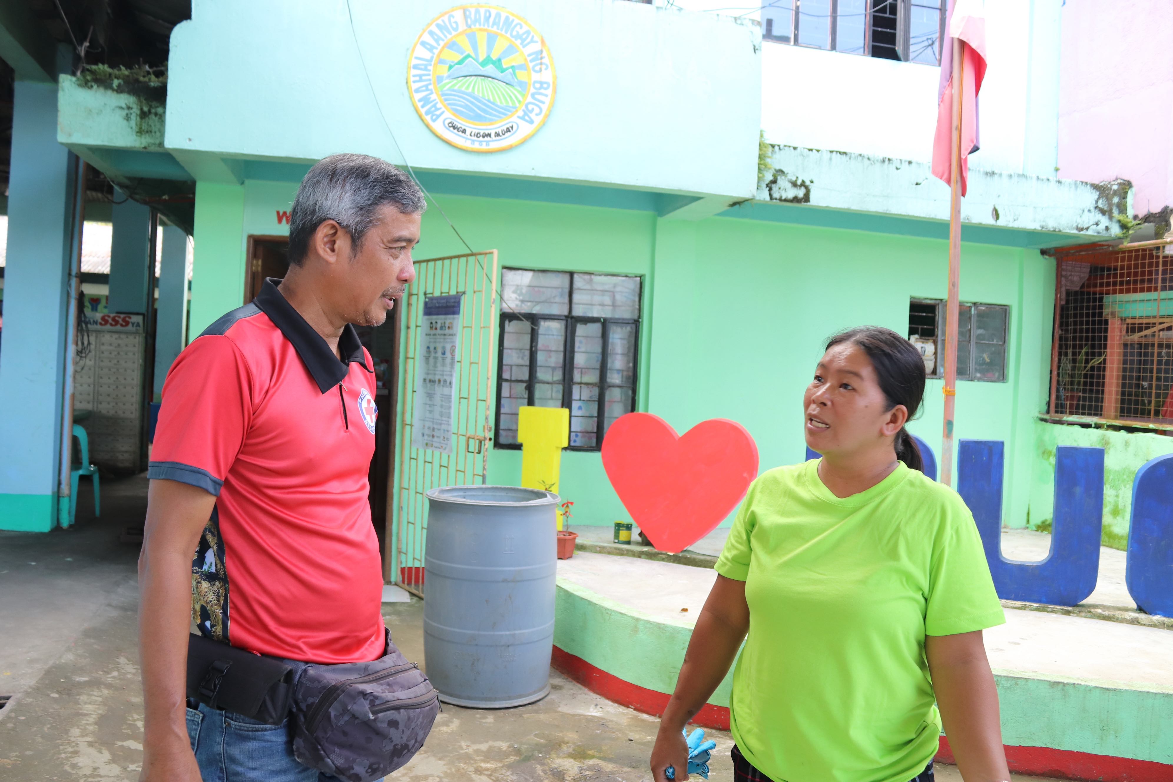 Storm survivor Jeanette Mata Septo chats with Gerald from the Albay chapter of the Philippine Red Cross. 