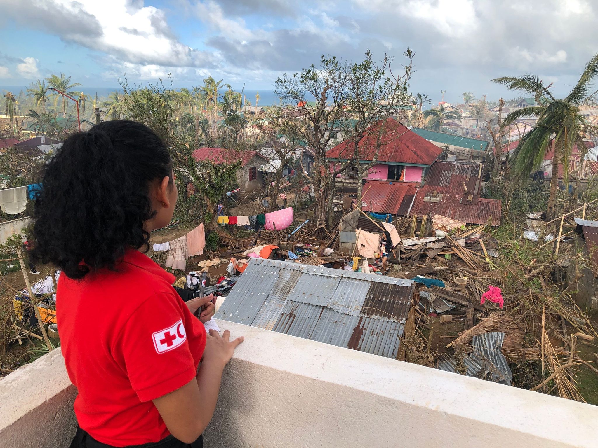 A volunteer surveys the damage caused by the rapid succession of typhoons that hit the Philippines in November 2024. 