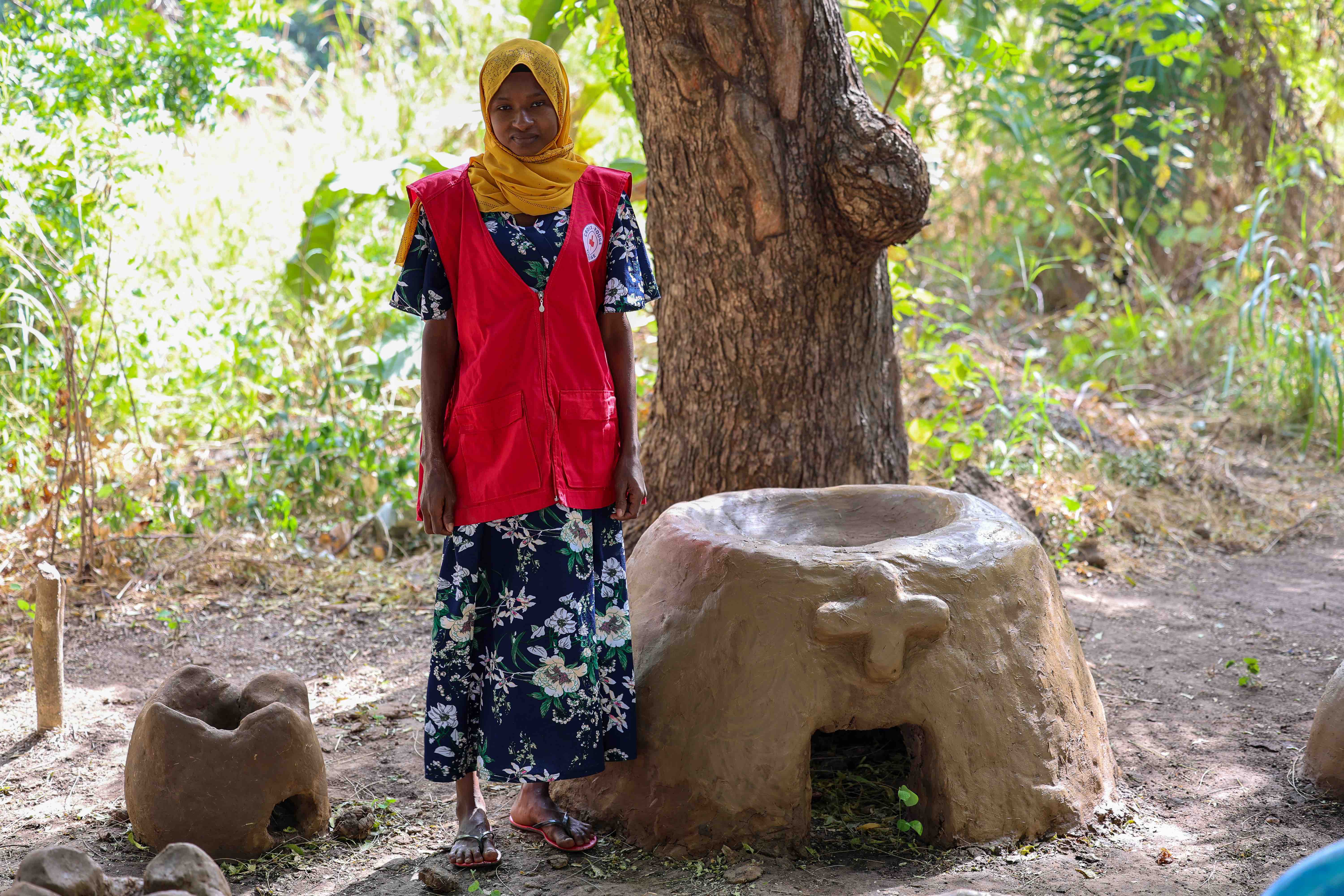 Mothers’ Club Member, Alima Abubakar from the Oumalo Community in northern Togo, stands by one of the earthen stoves made to reduce the amount of coal and firewood used in cooking.