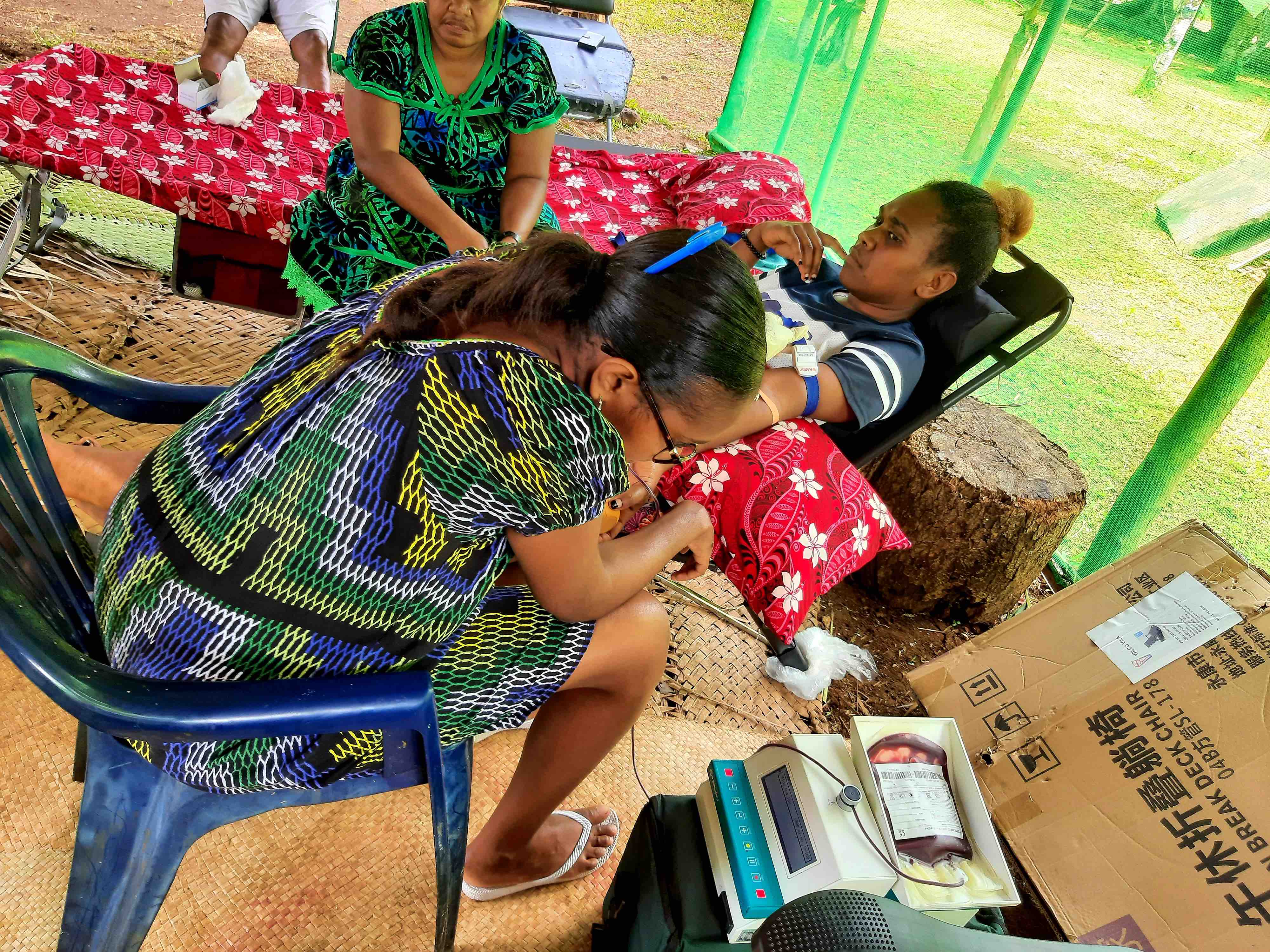 A woman reclines on a cot while donating blood during a Vanuatu Red Cross blood donation drive following the December 2024 earthquake.