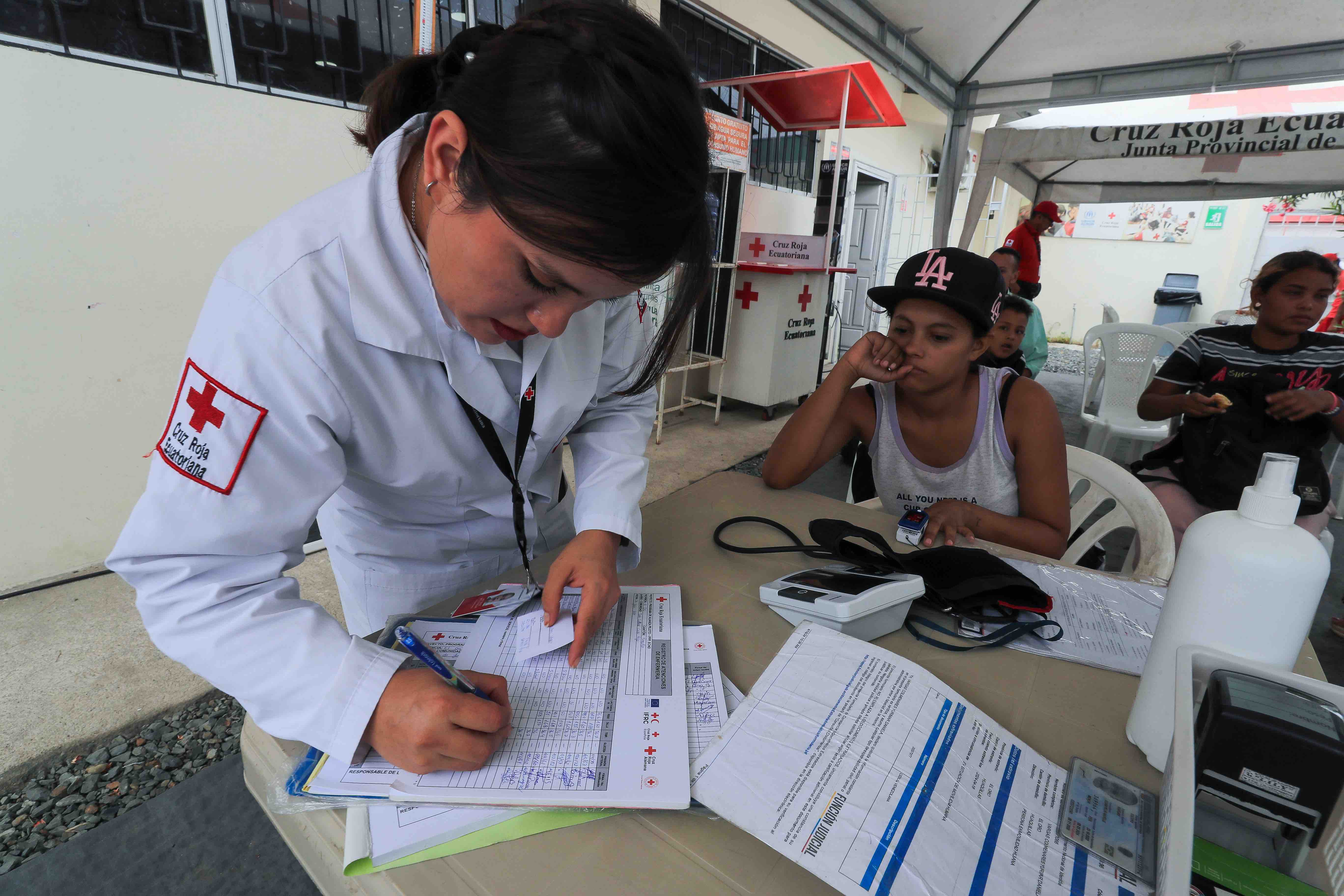 A staff member of the Ecuadorian Red Cross begins the process of offering free medical and psychological care to a young migrant in Huaquillas, Ecuador. Hunger, malnutrition, dehydration, stress and various illnesses and ailments are some of the issues facing people on the move.